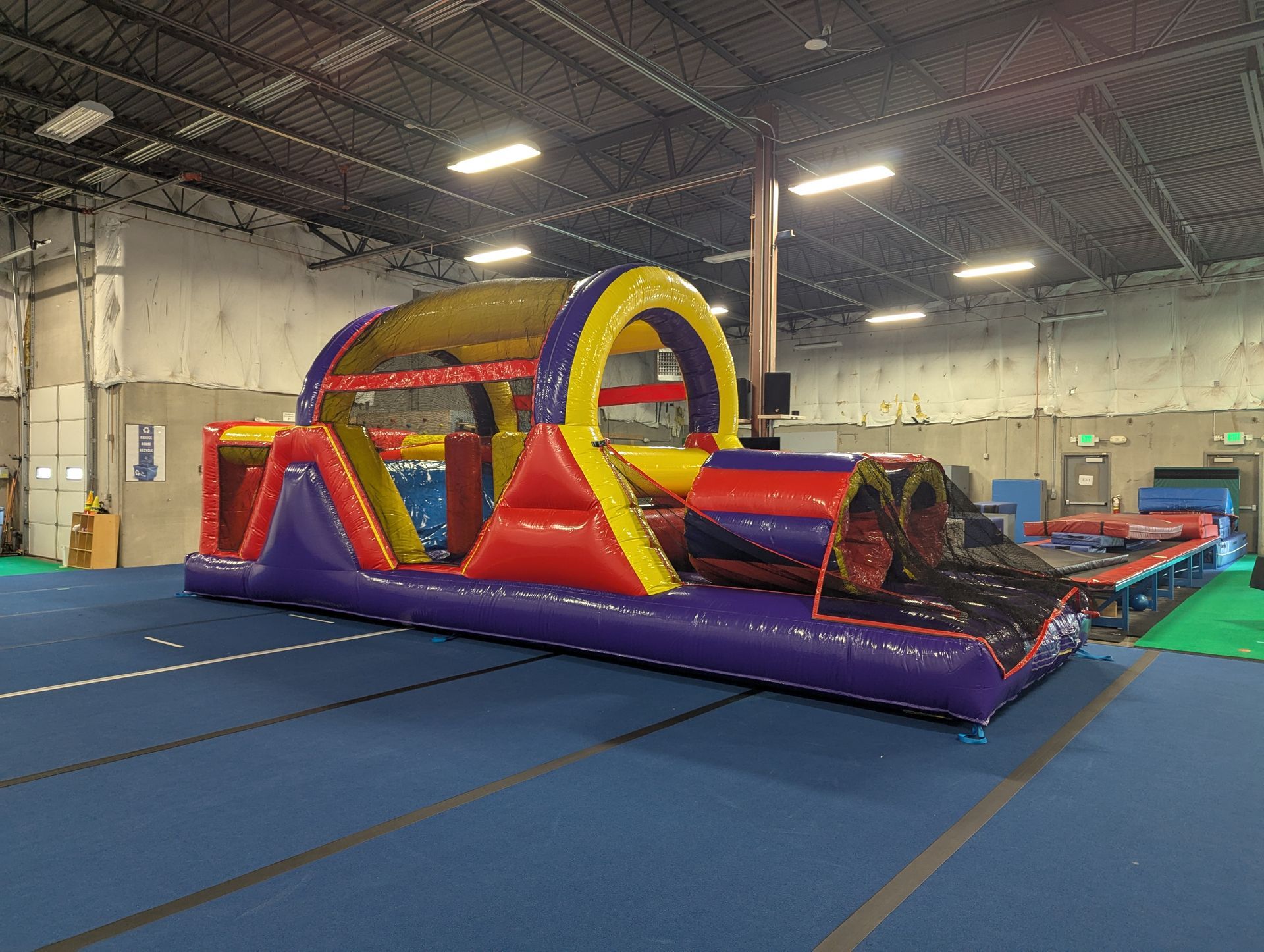 A large inflatable obstacle course in a gym.