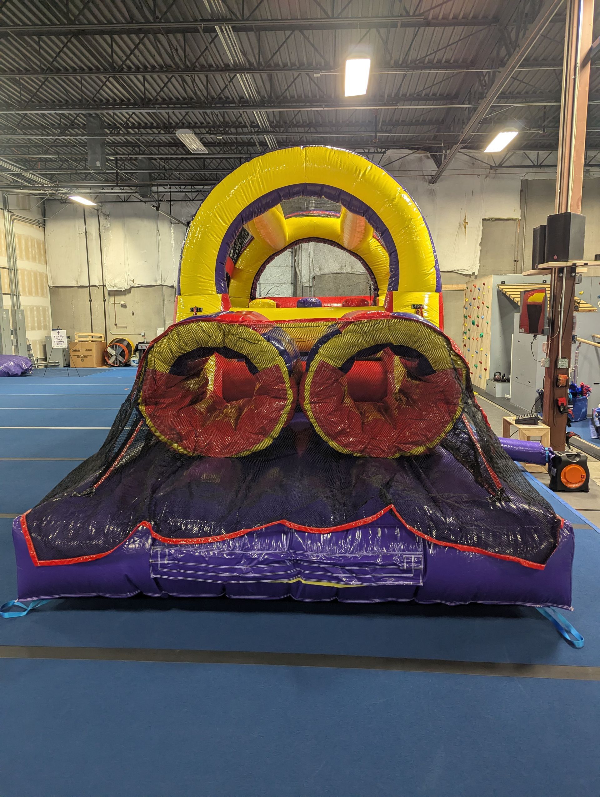 A large inflatable obstacle course is sitting in a gym.