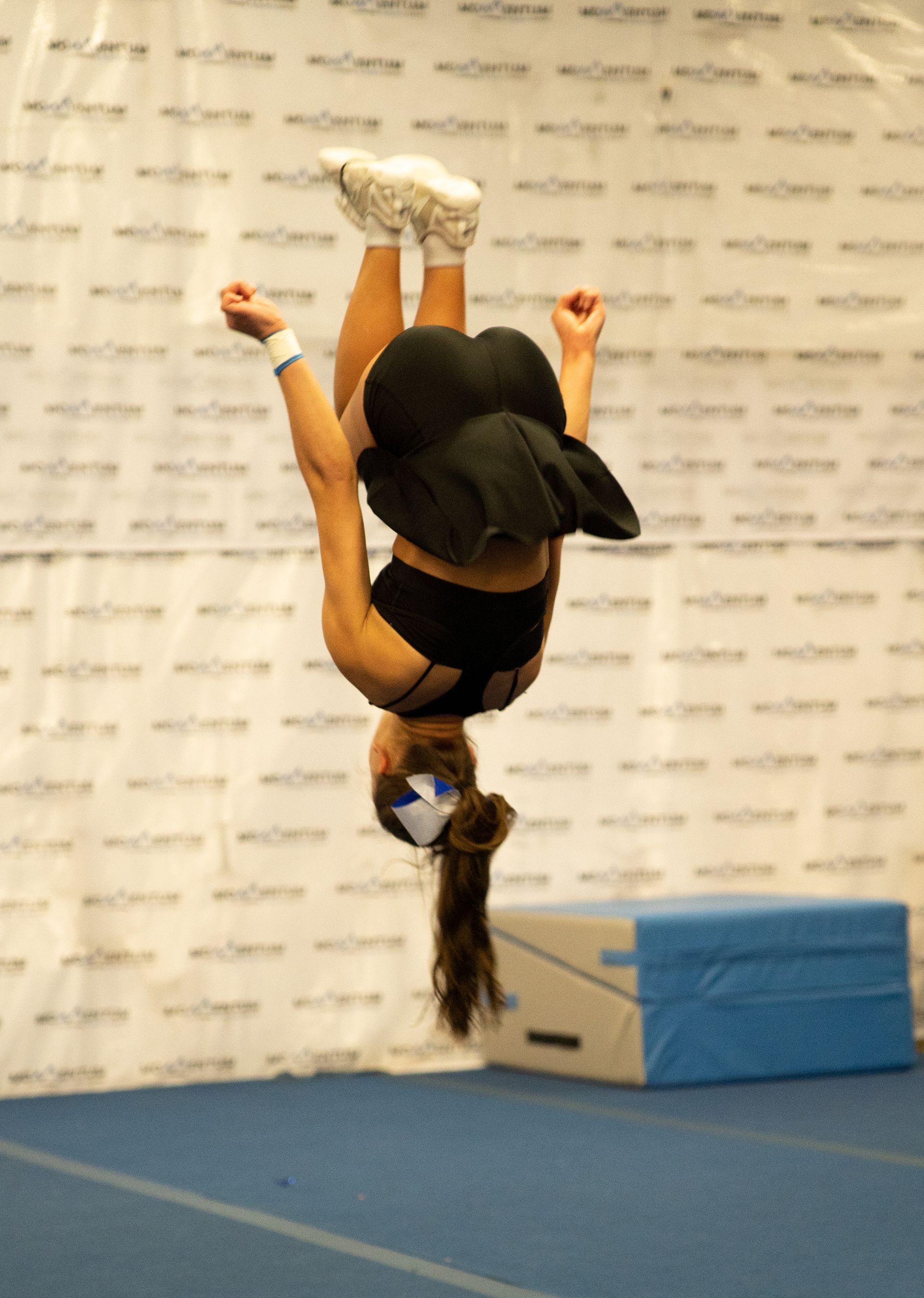 A woman is doing a handstand in a gym