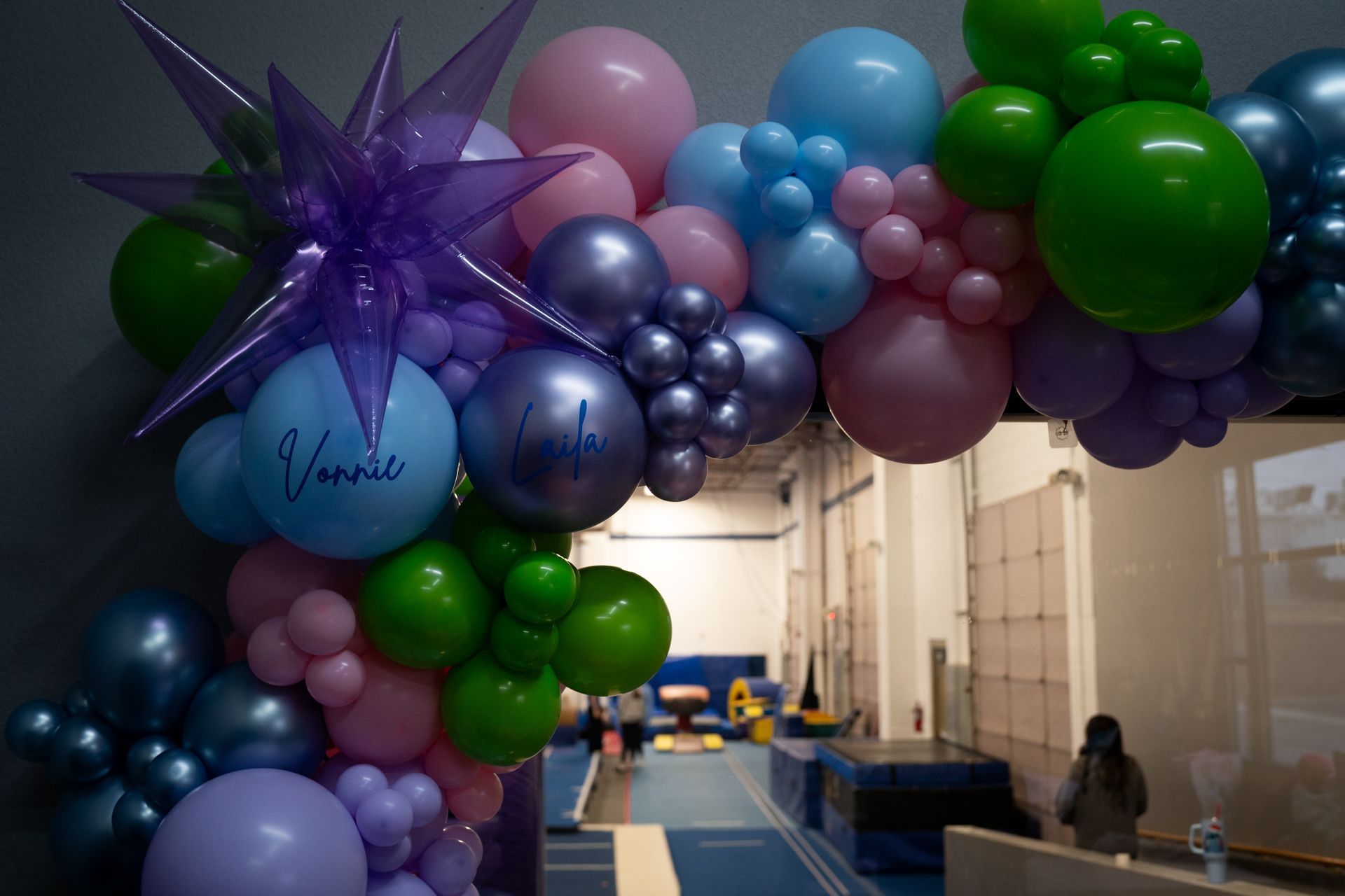 A bunch of balloons are hanging from the ceiling in a room.