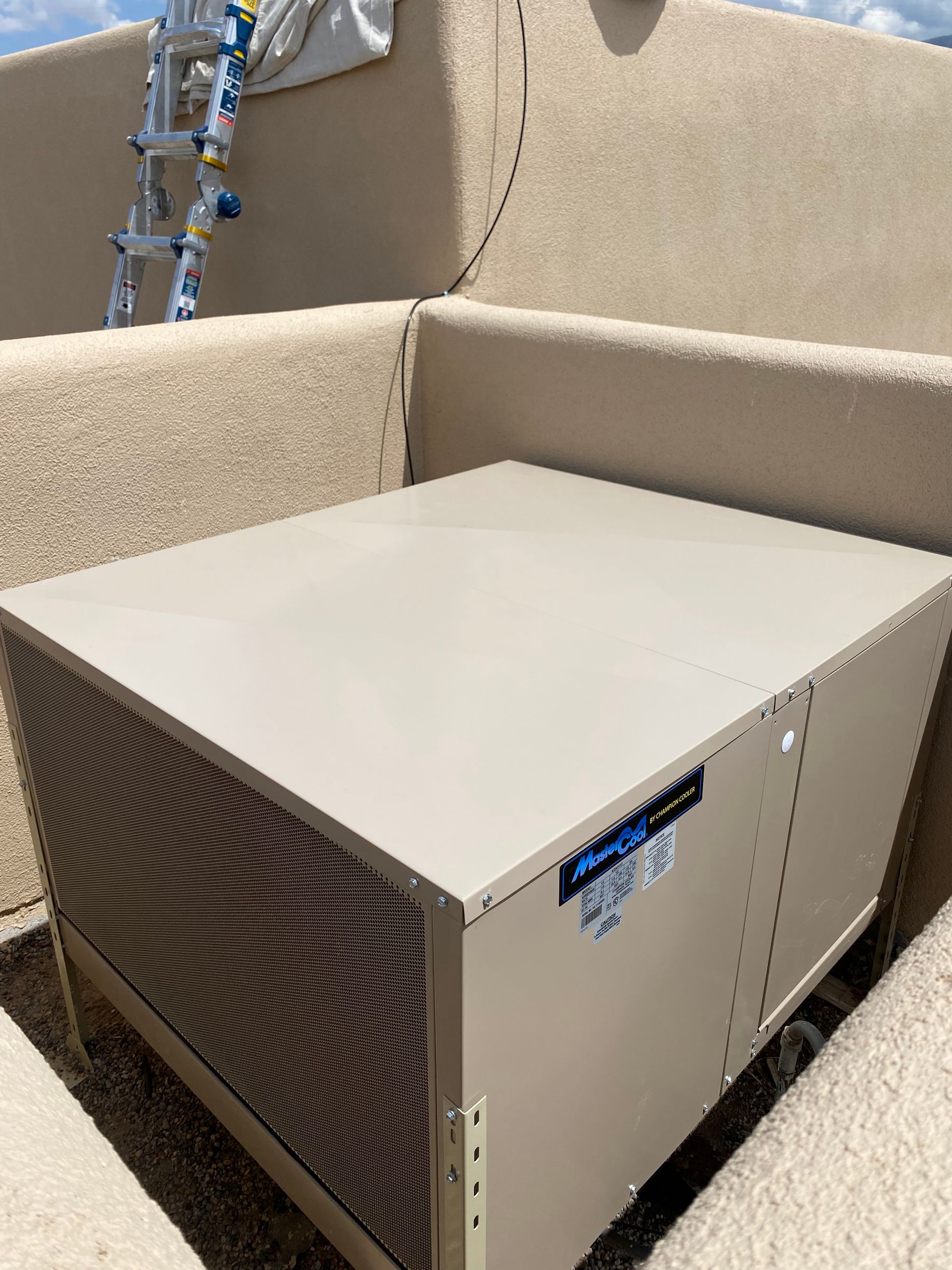 A large box is sitting on top of a concrete wall.