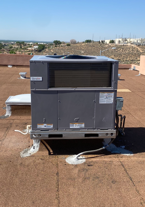 A large air conditioner is sitting on top of a roof.