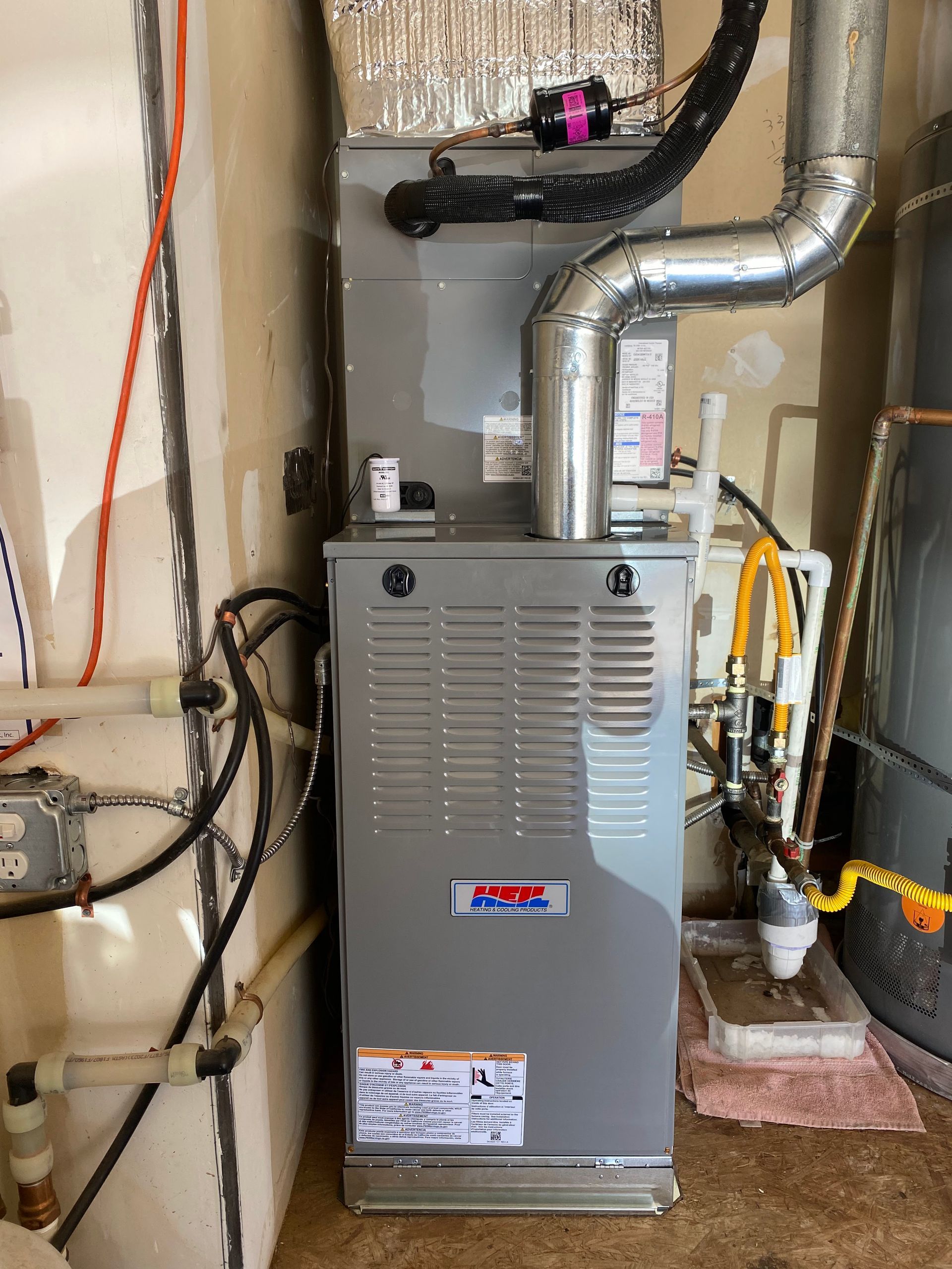 A gas heater is sitting in a room next to a wall.