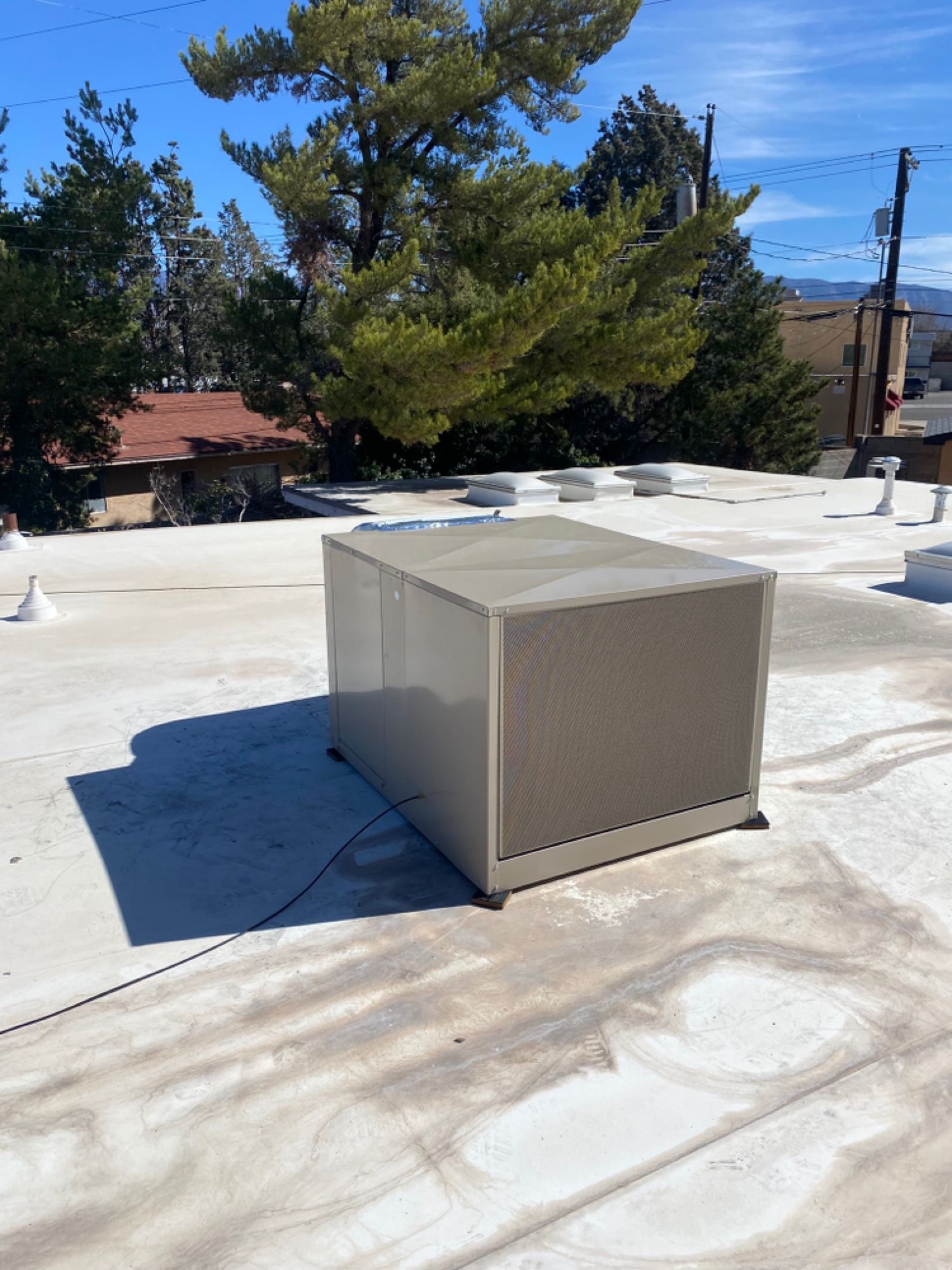 A box is sitting on top of a white roof.