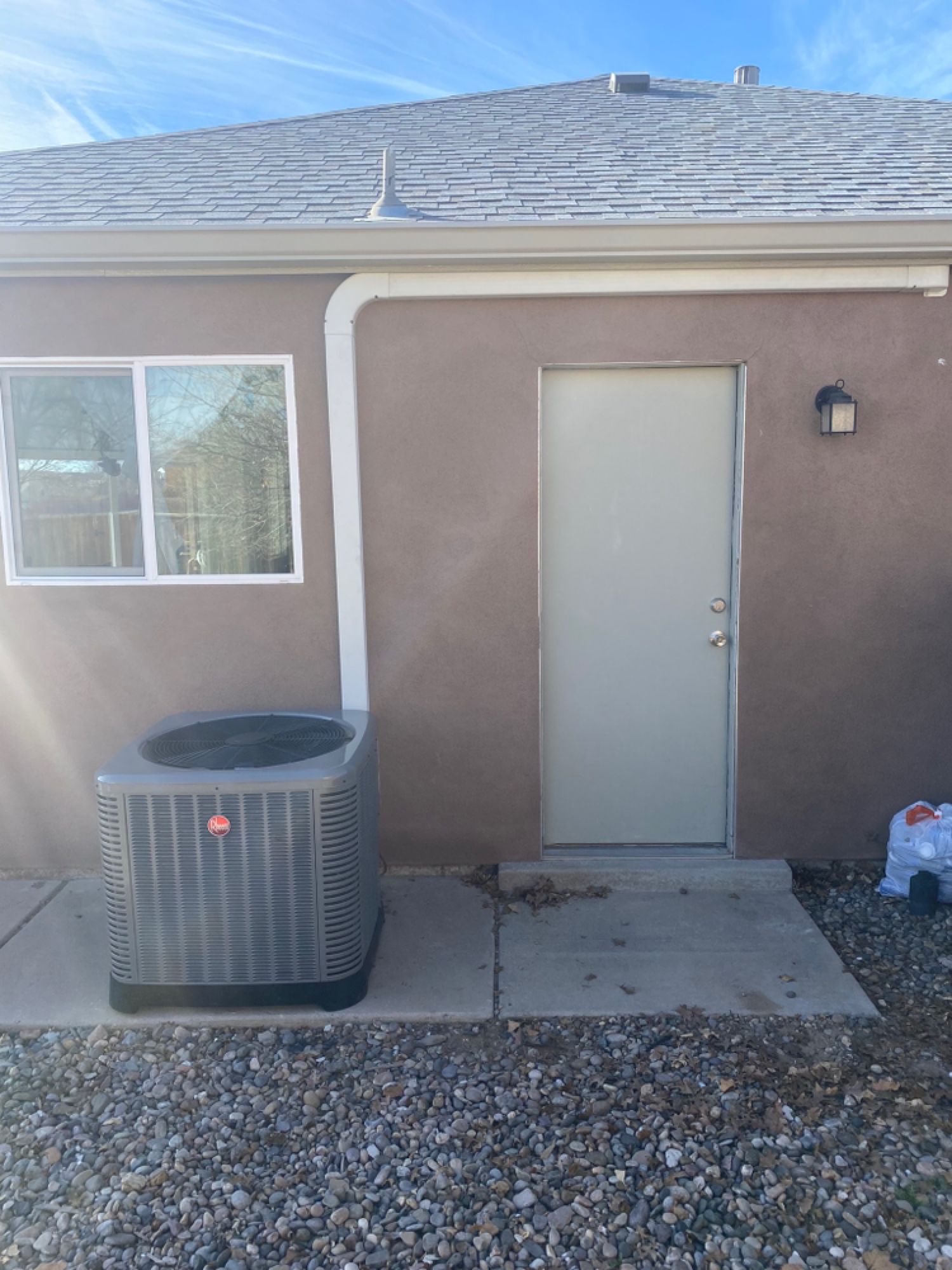 There is a window and a door on the side of the house.