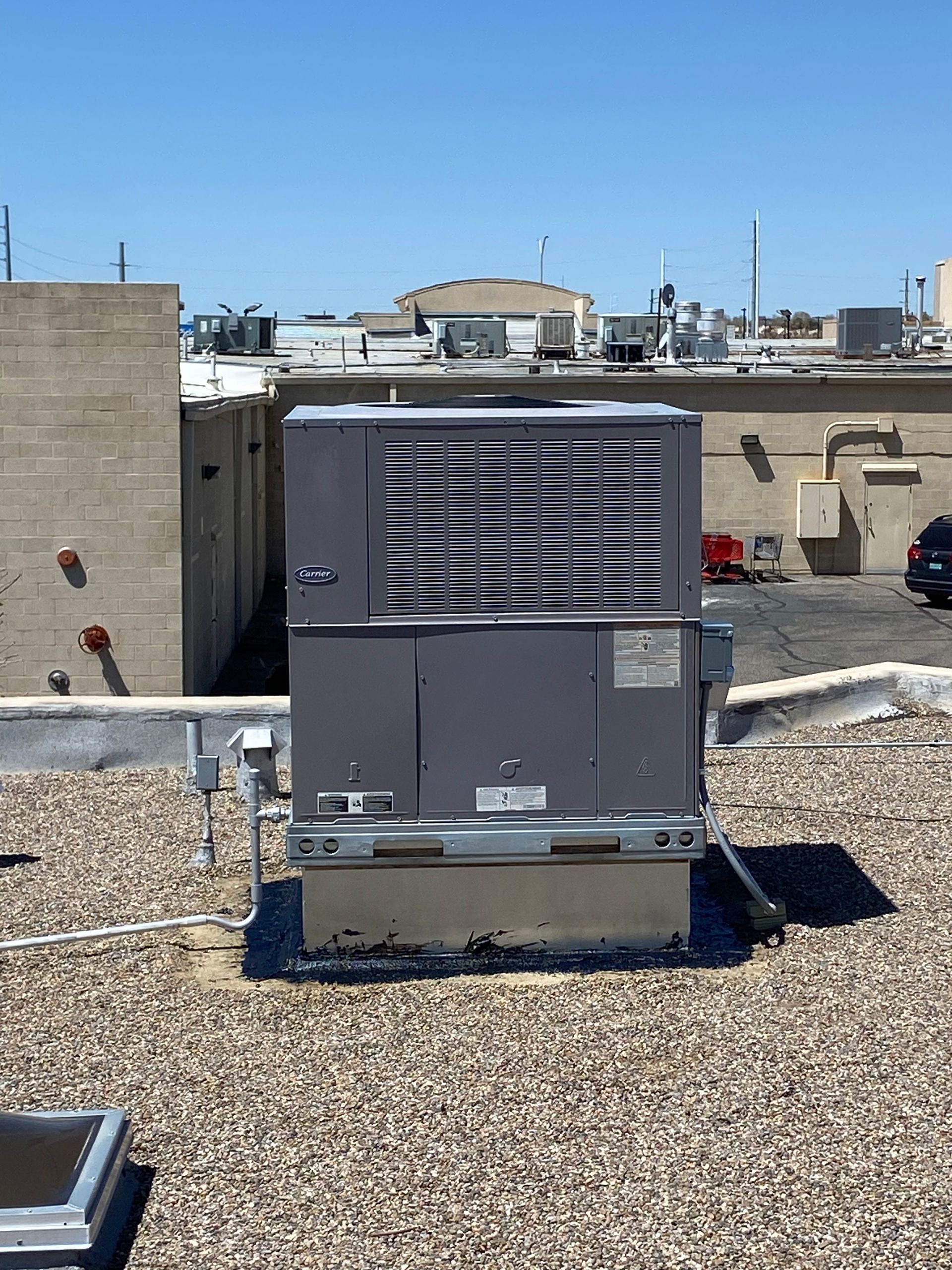 An air conditioner is on the roof of a building