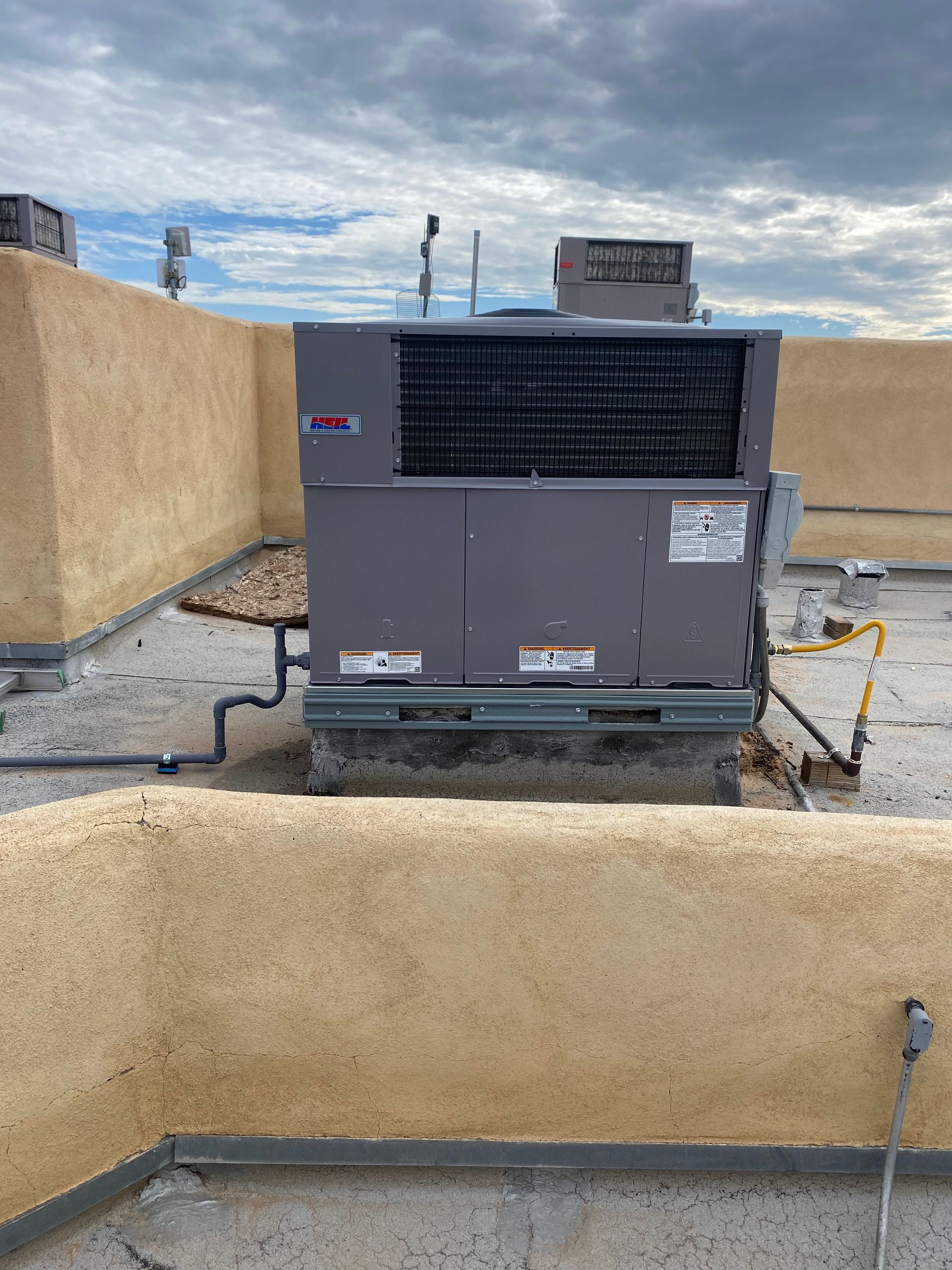 A large air conditioner is sitting on top of a building.