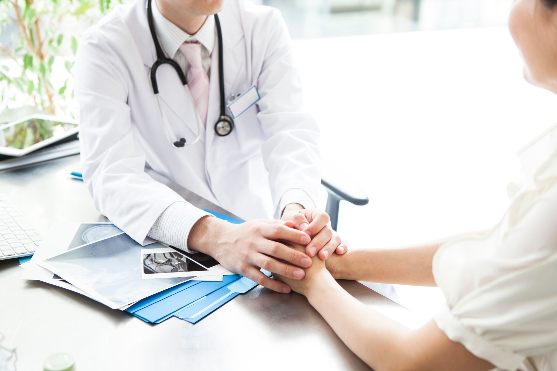 Caring doctor, holding patient hands, showcasing primary care services and support.