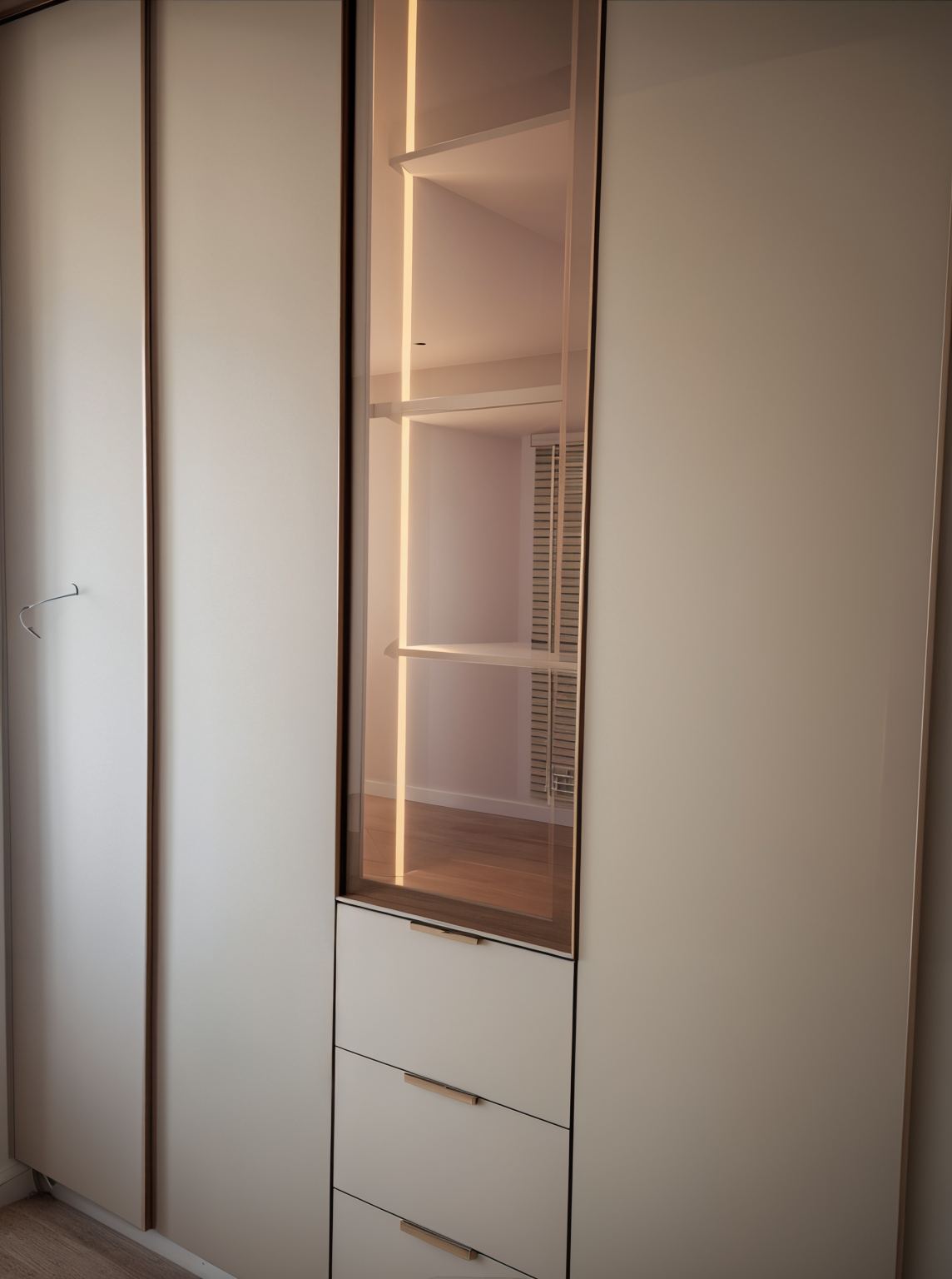 Built-in wardrobe with glass display cabinet and drawers. Warm lighting illuminates the interior.