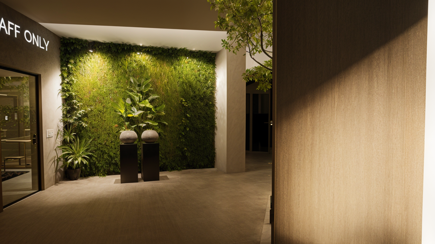 Entrance with a living green wall, lit by spotlights.