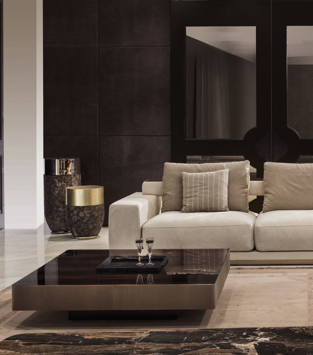 Living room with cream sofa, chairs, TV, and modern light fixtures. View into dining area.
