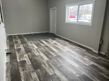 A living room with hardwood floors and a window.