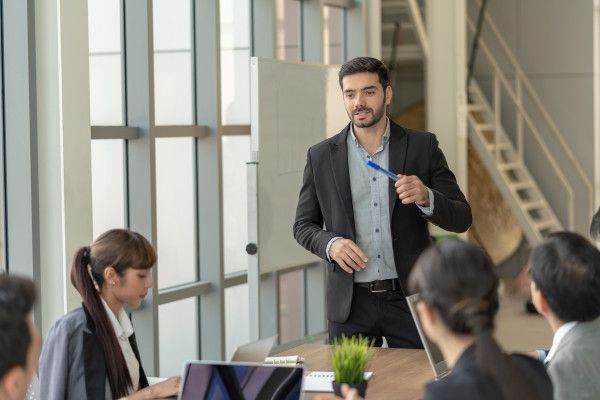 A man is giving a presentation to a group of people in a conference room.