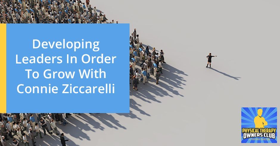 A group of people are standing in a line with a blue sign that says developing leaders in order to grow with connie ziccarelli