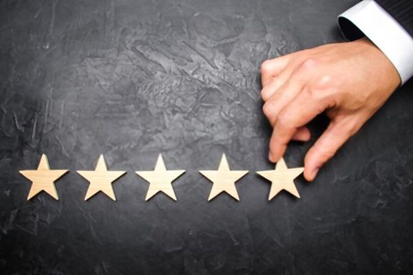 A person is pointing at a wooden star on a blackboard