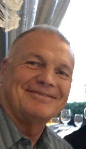 A close up of a man 's face smiling in a restaurant.