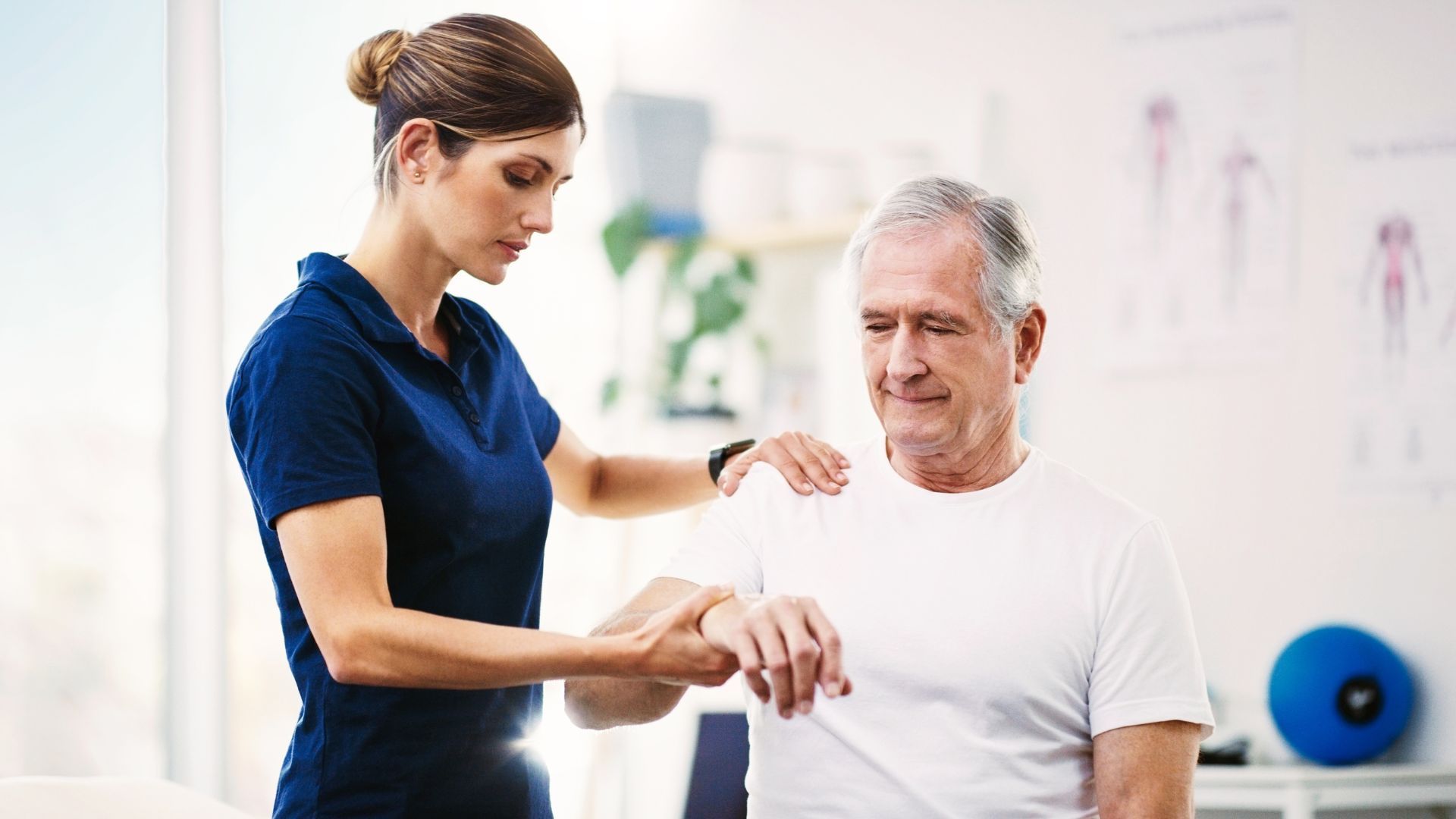 A man and a woman are looking at a tablet in a gym.