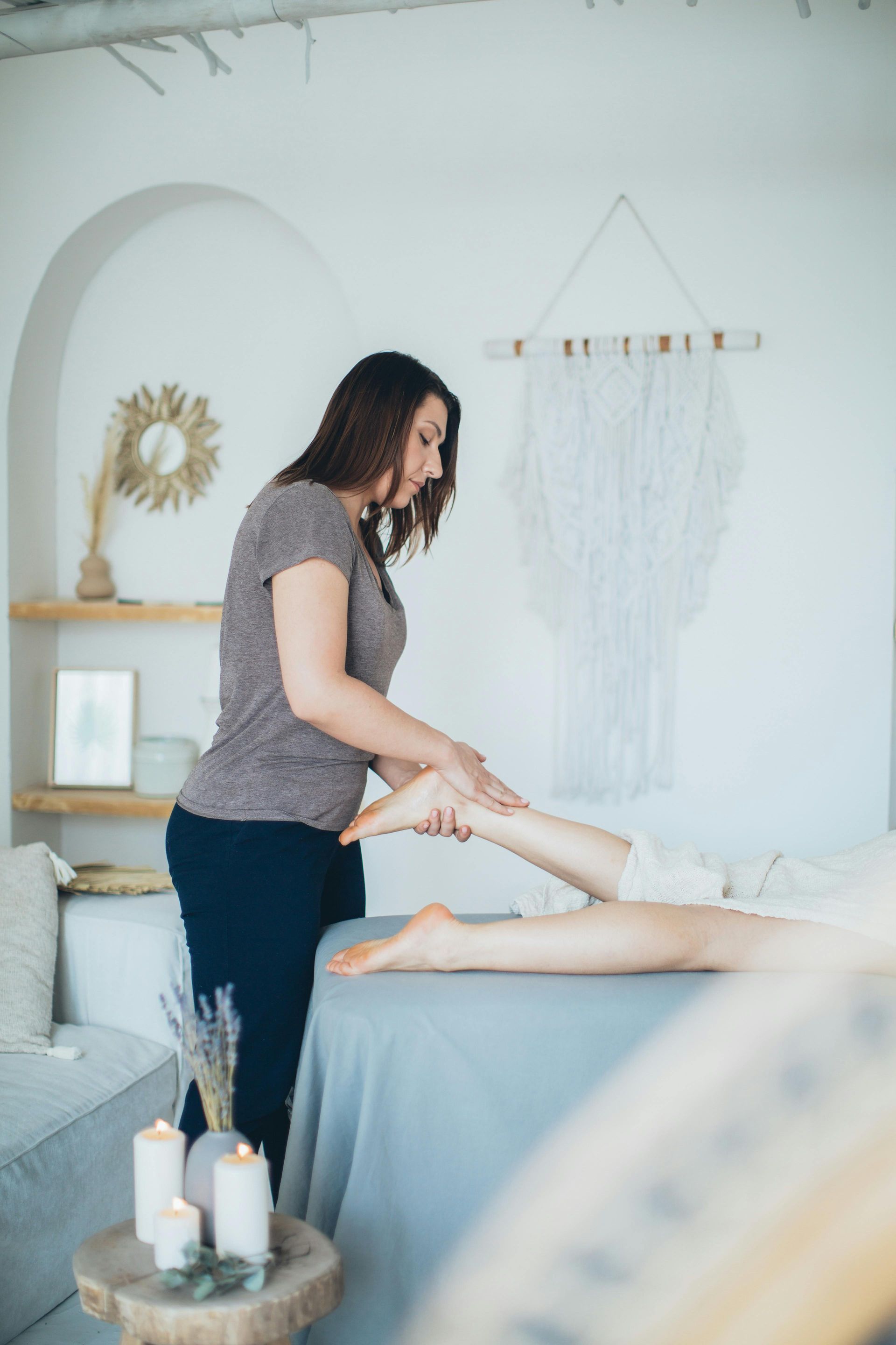 A woman is giving a foot massage to a woman in a room.