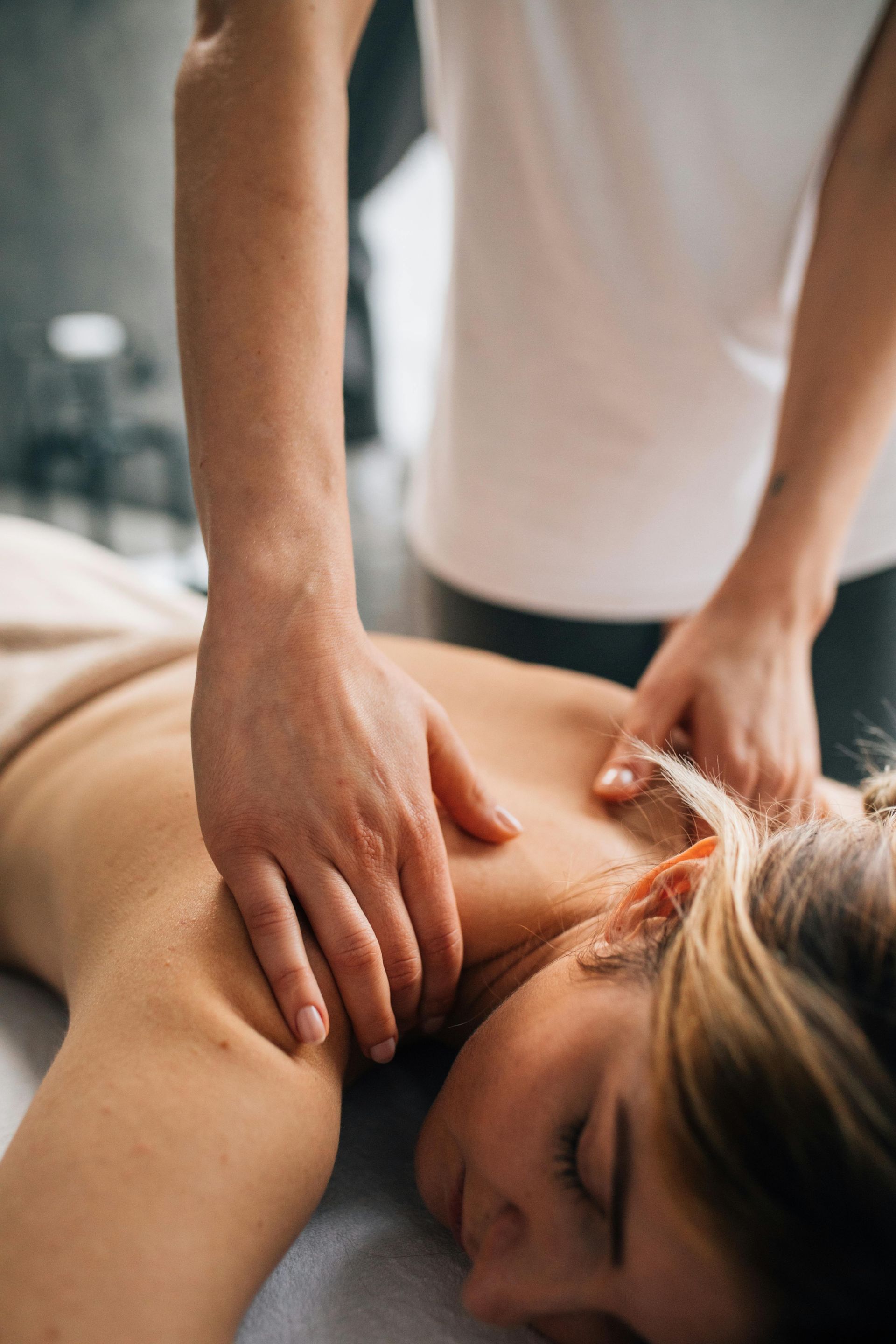 A woman is laying on a bed getting a massage from a man.
