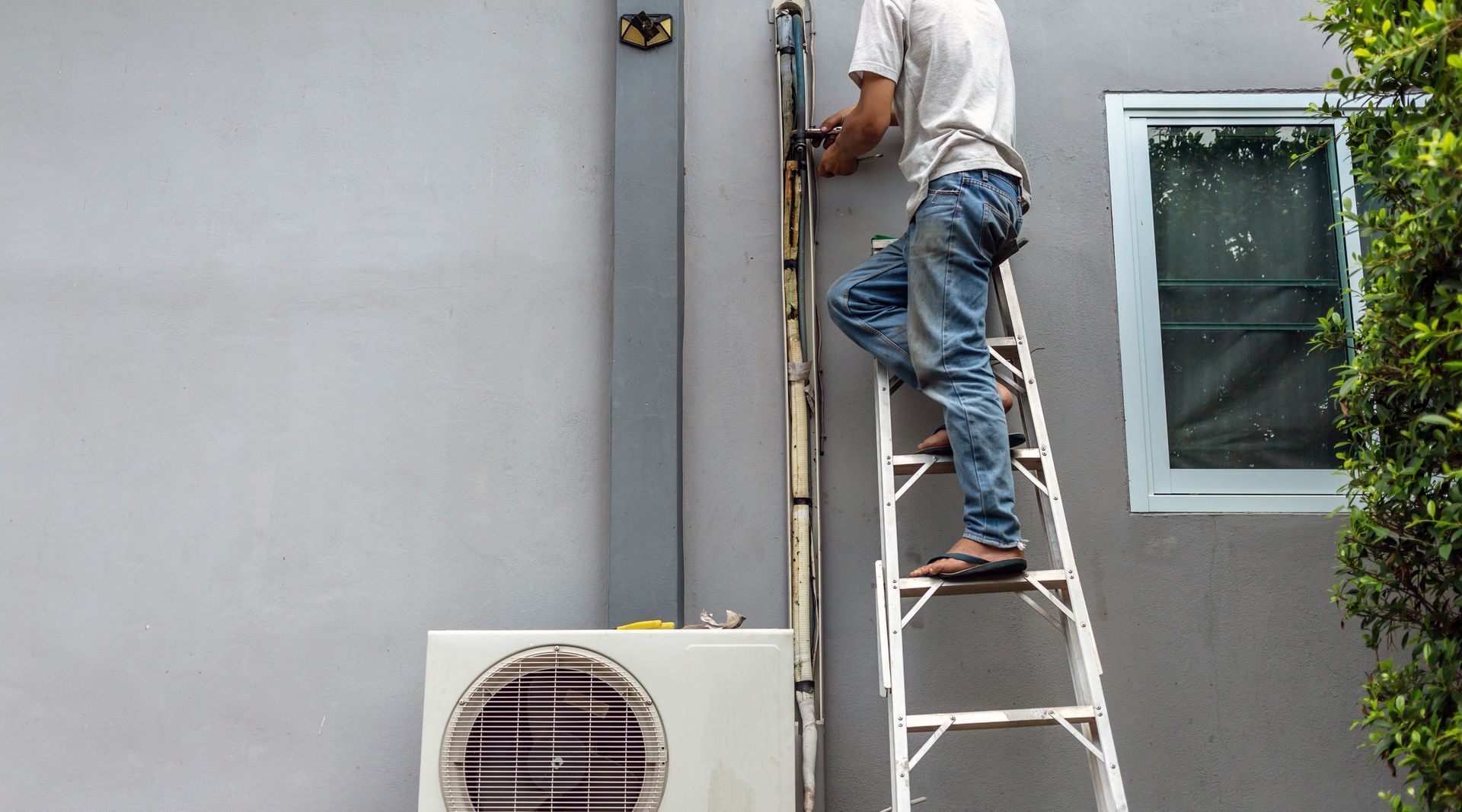 Technician repairing and dismantling the air duct outdoor air conditioning system.