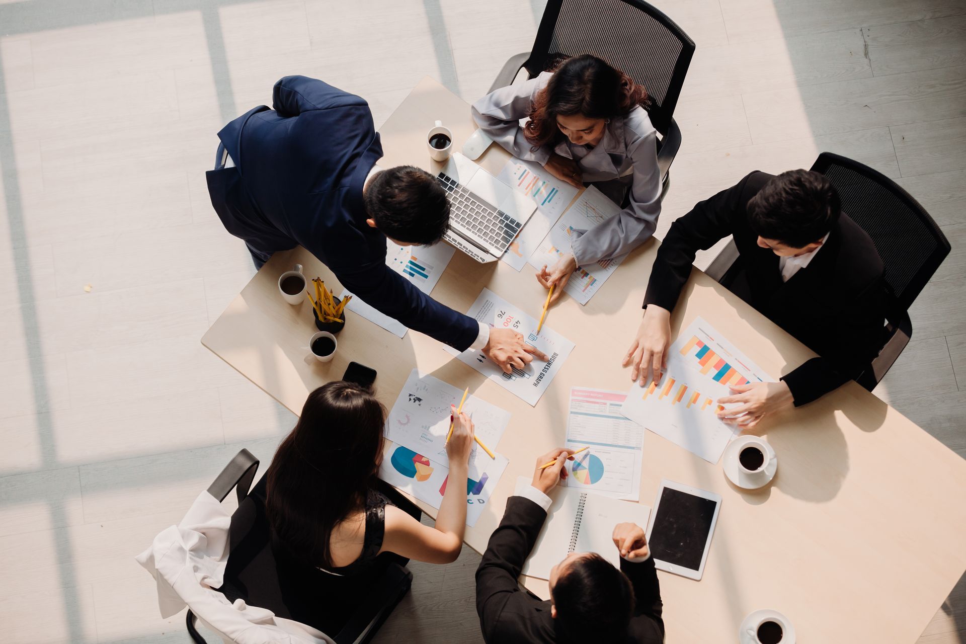 A group of people are sitting around a table having a meeting.