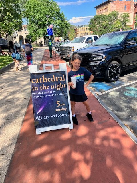 Girl poses next to a sign for 