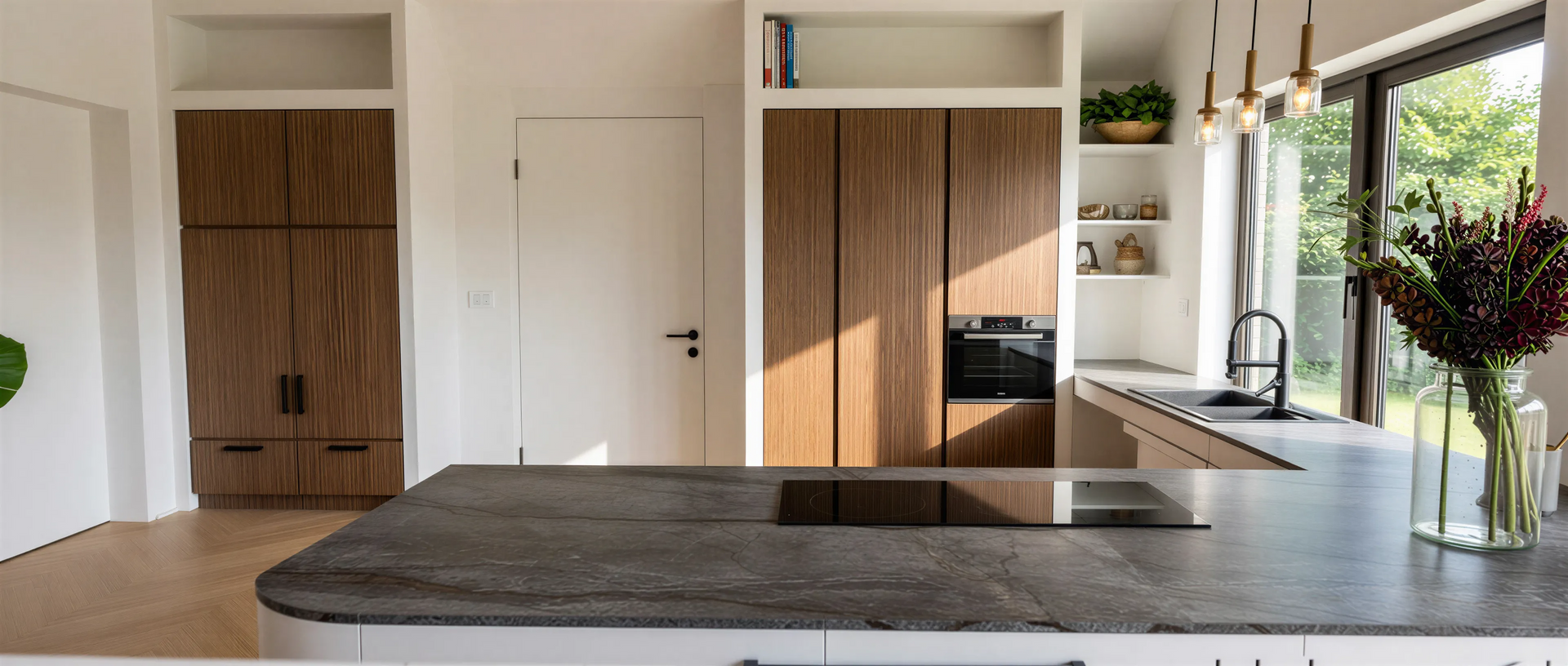 Moderne keuken met houten kasten, donker aanrechtblad en groot raam.