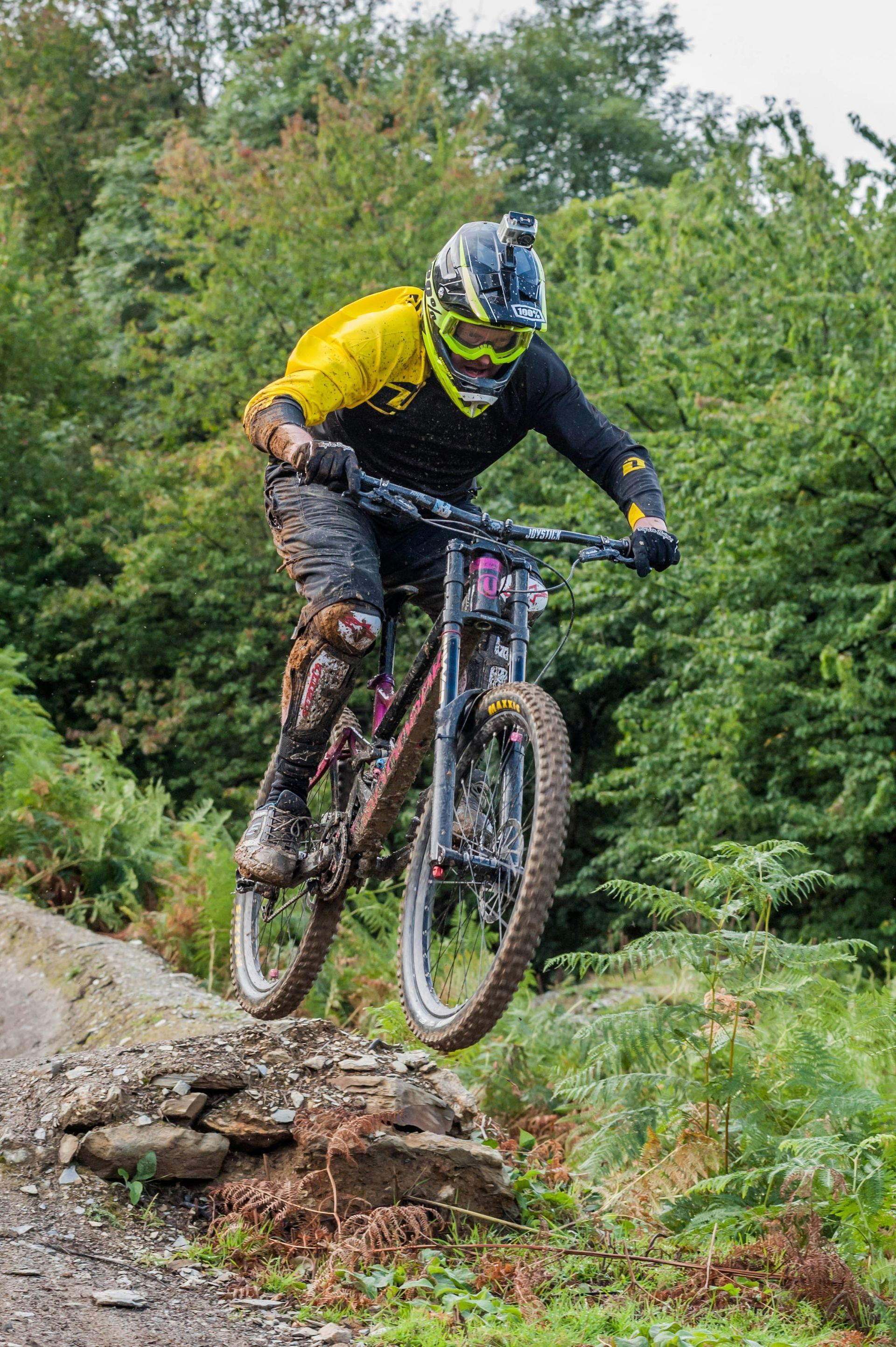 A man is riding a mountain bike down a trail in the woods.