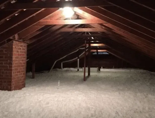 A dark attic with a brick chimney in the corner
