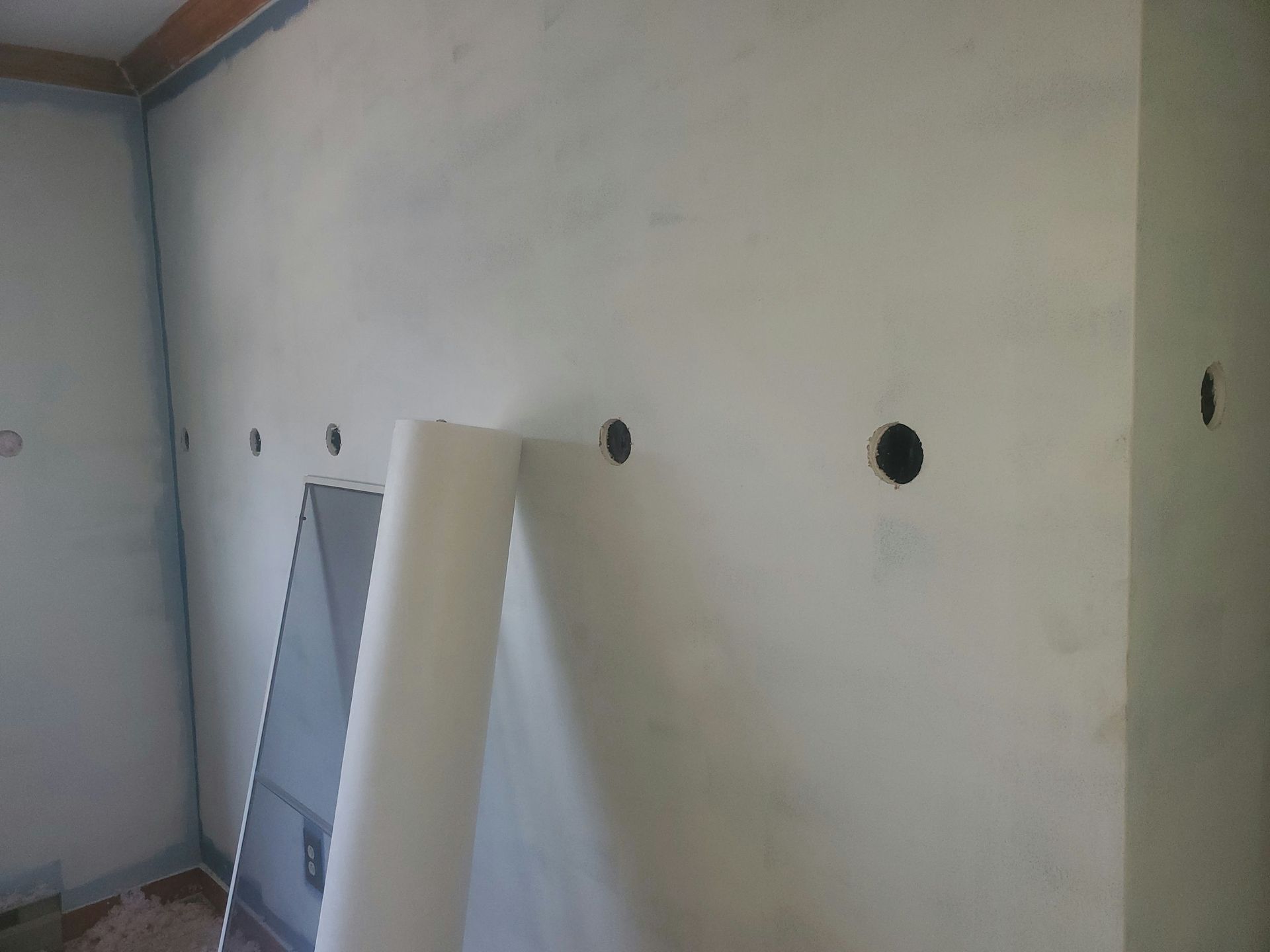A corner of a room with holes in the wall