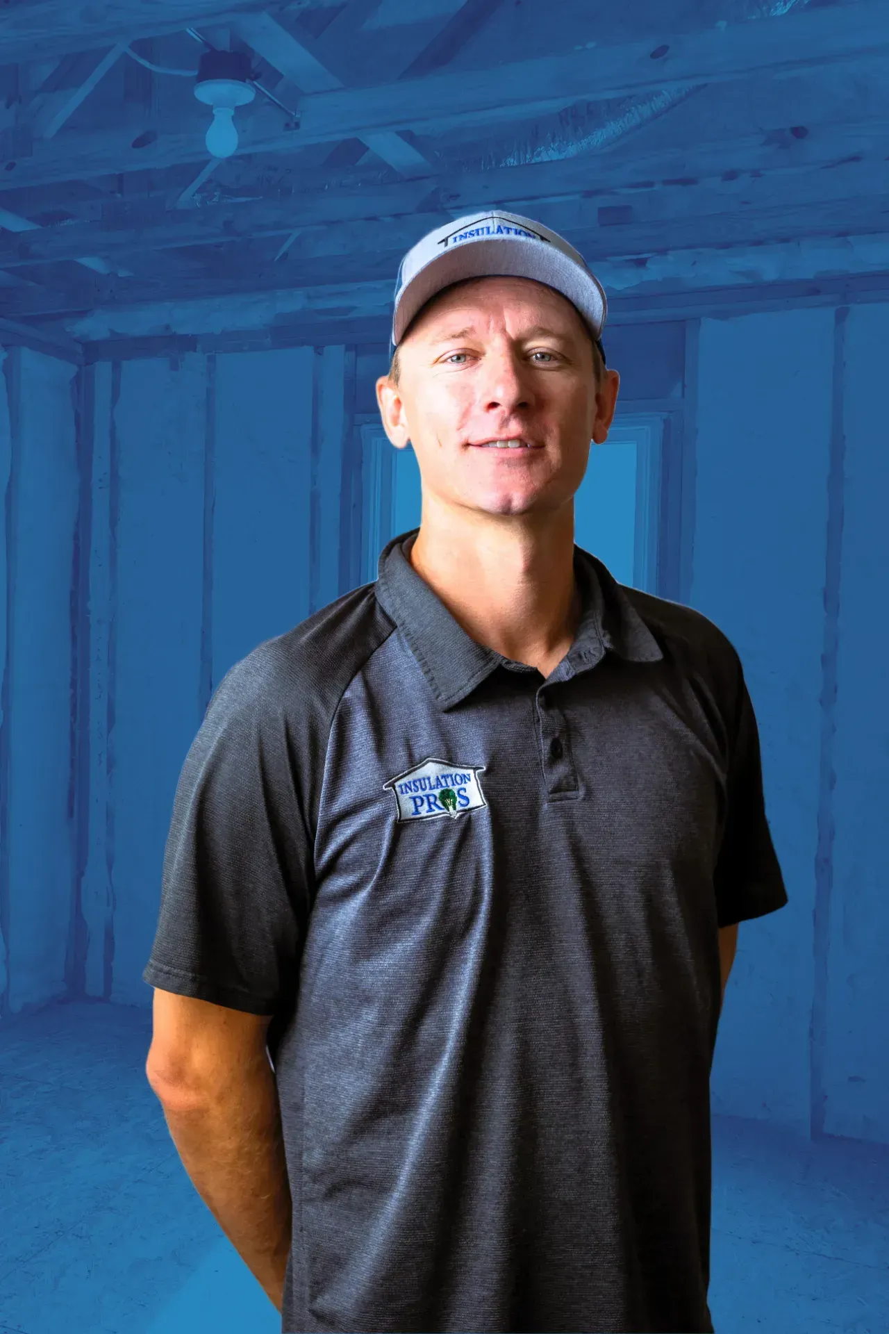 A man wearing a hat and a polo shirt is standing in a room with a blue background.