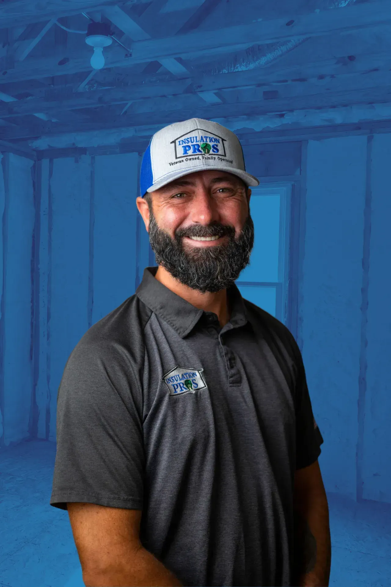 A man with a beard is wearing a hat and a polo shirt.