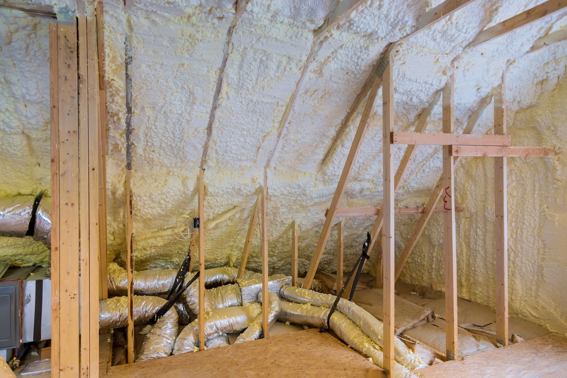 A room with a lot of pipes and foam on the ceiling.