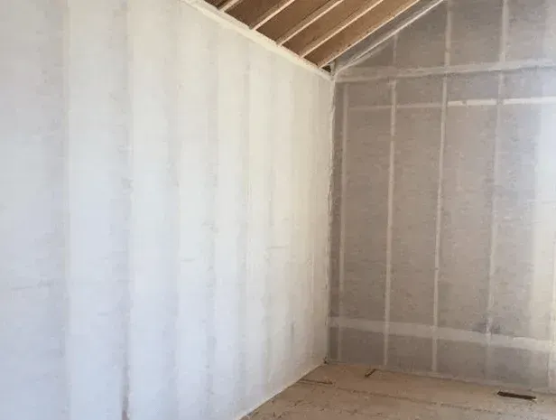 A room with white walls and a wooden ceiling.