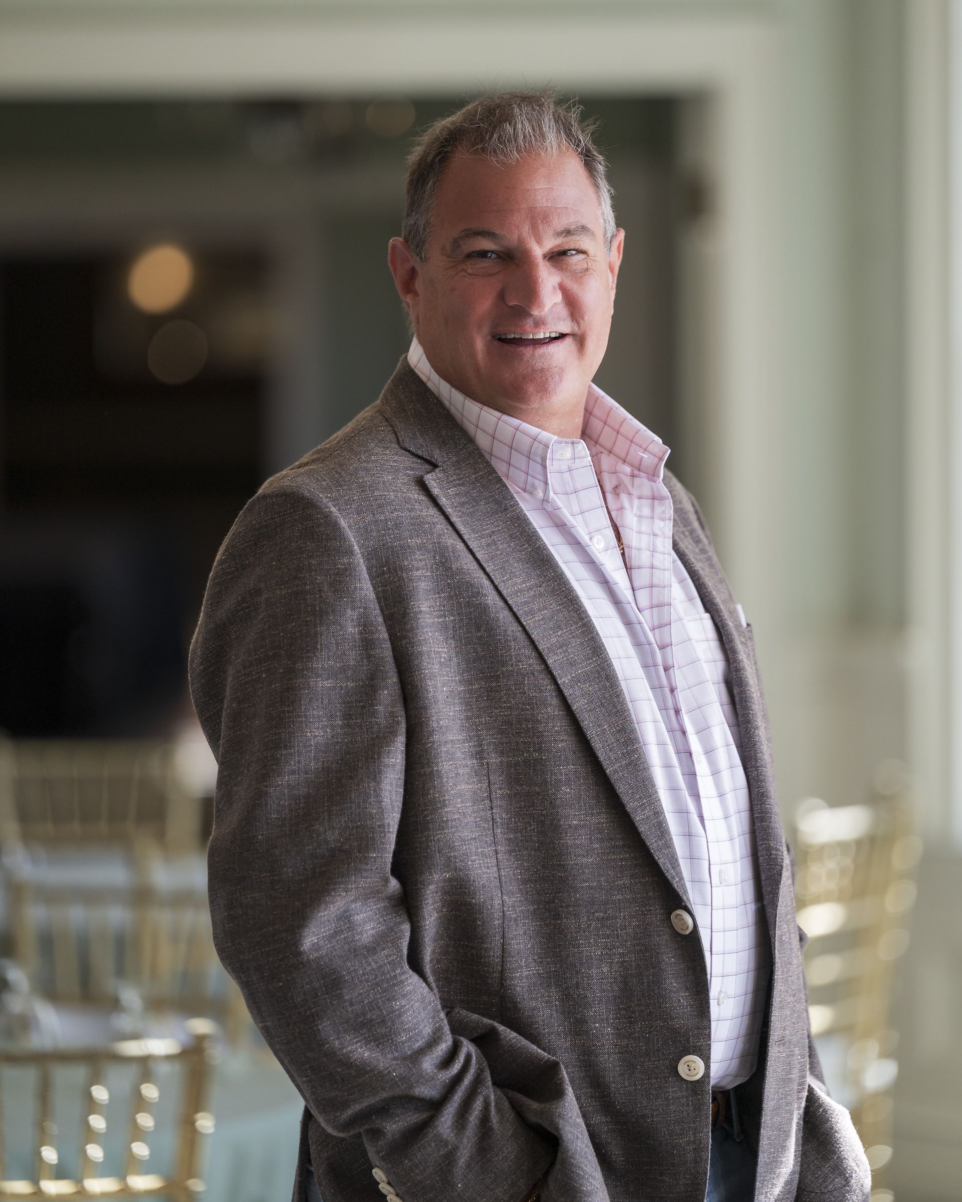 A man in a suit is standing with his hands in his pockets