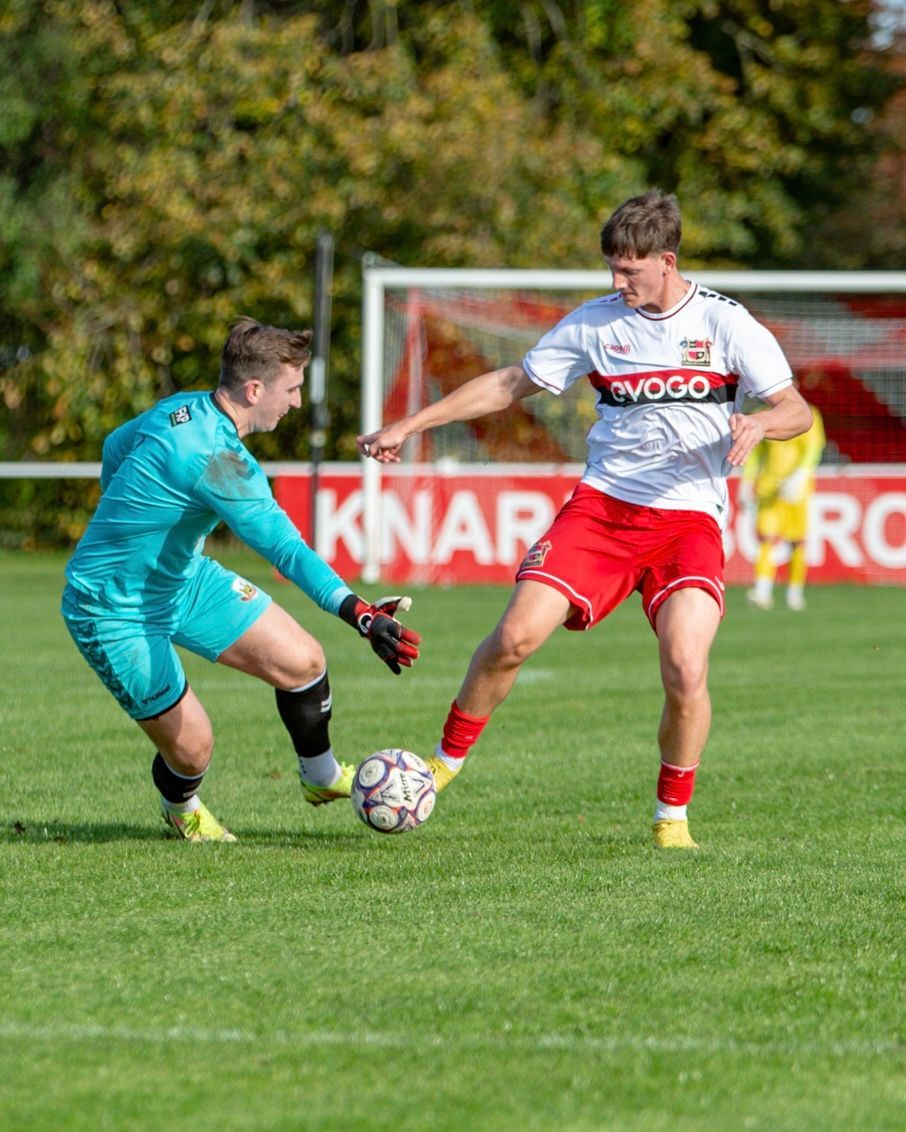 White upholstered armchair with light wood legs and black metal supports.