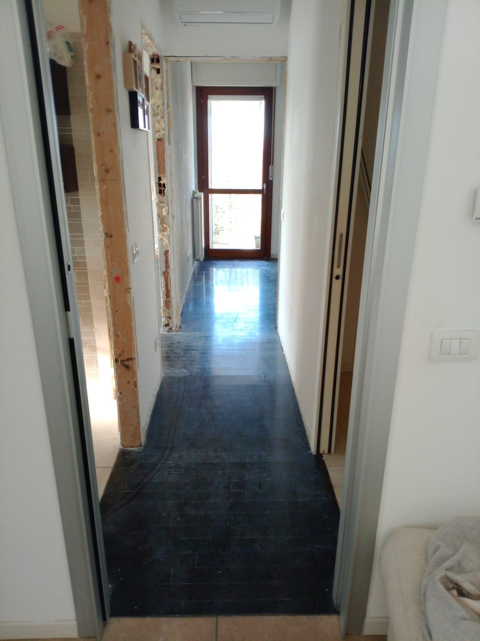 Un corridoio con una porta e una finestra in una casa.