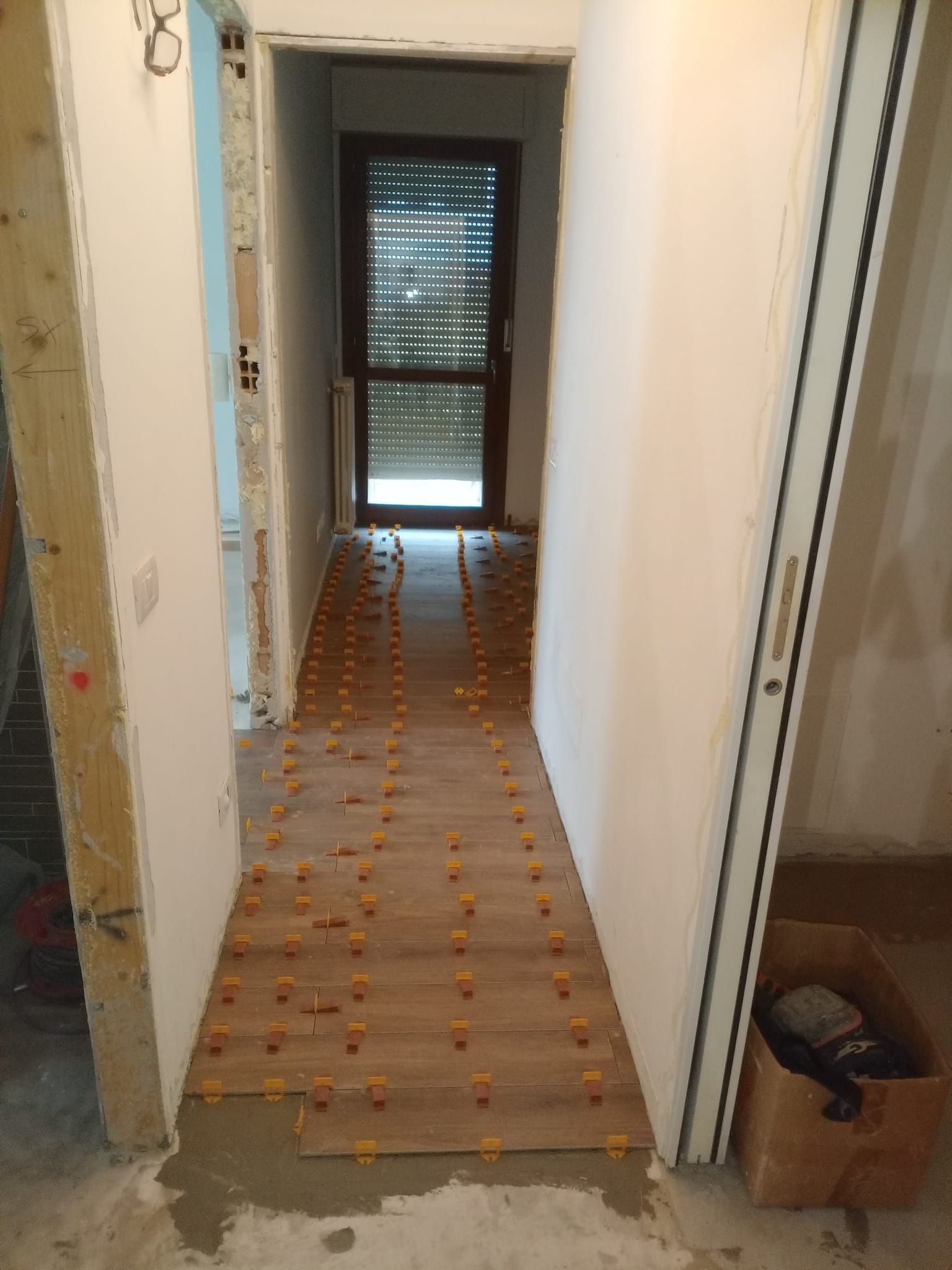 Un corridoio con pavimento in legno e una porta.