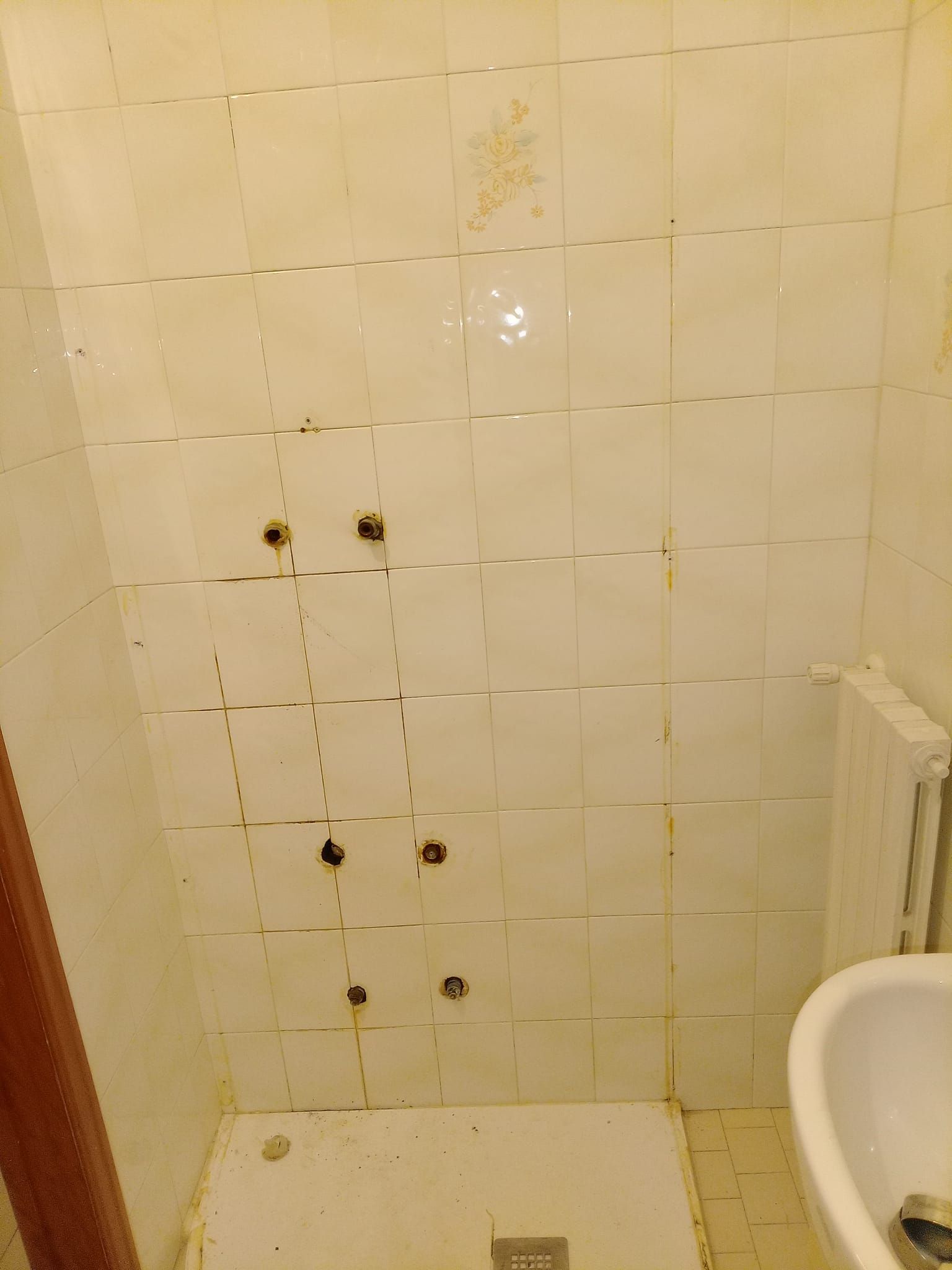 Un bagno con piastrelle sporche e un lavandino.