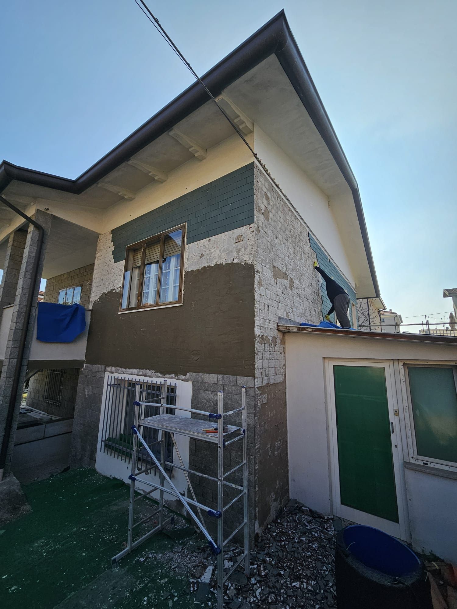 Si sta dipingendo una casa con un'impalcatura davanti.