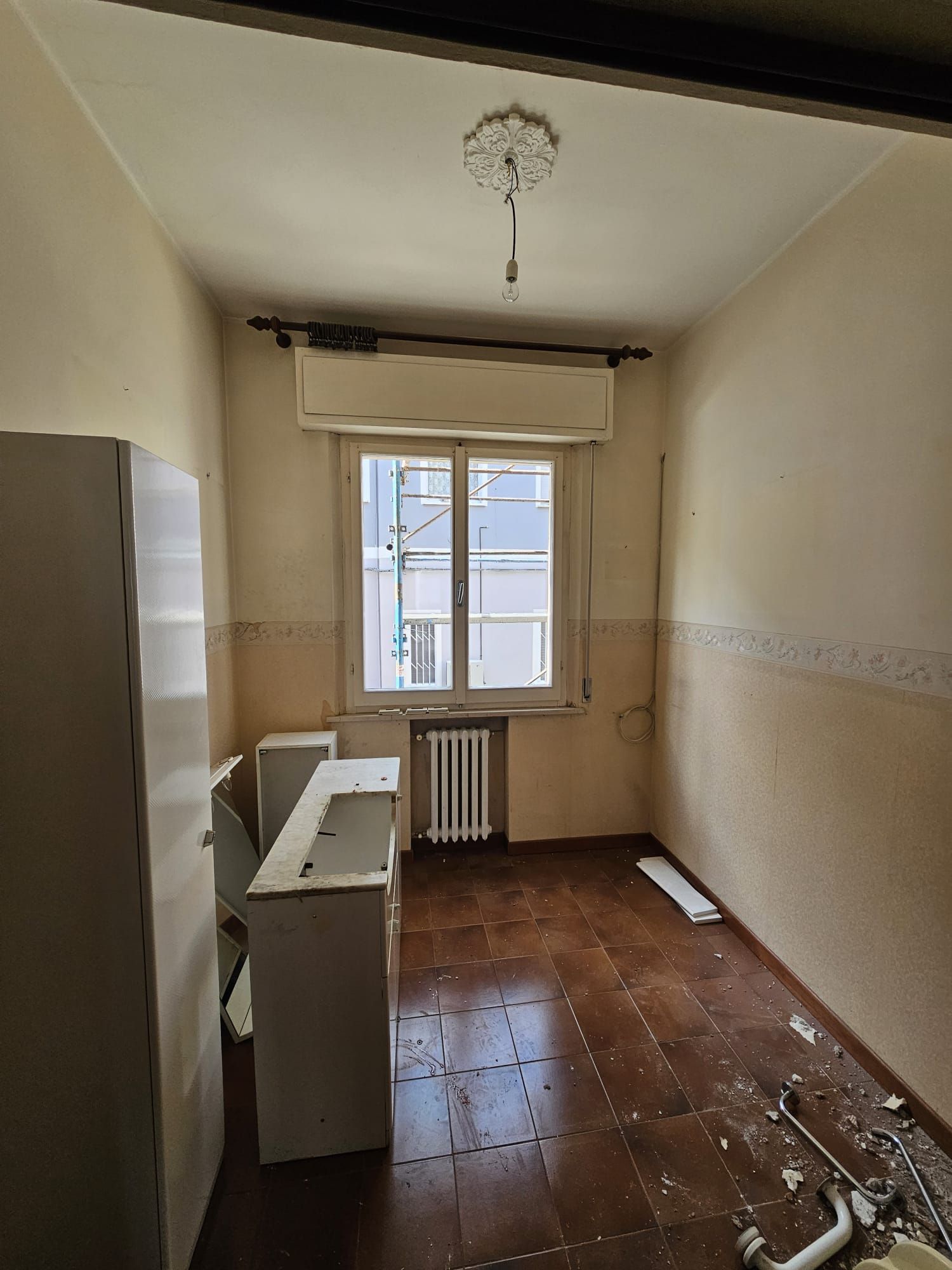 Una stanza vuota con una finestra e un termosifone