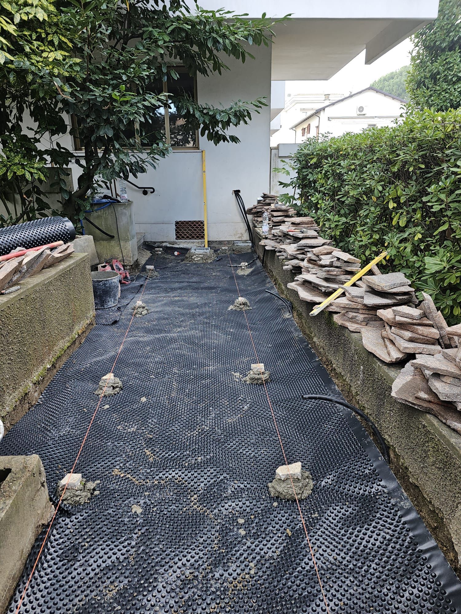 Un sistema di drenaggio è in fase di installazione nel cortile di una casa.