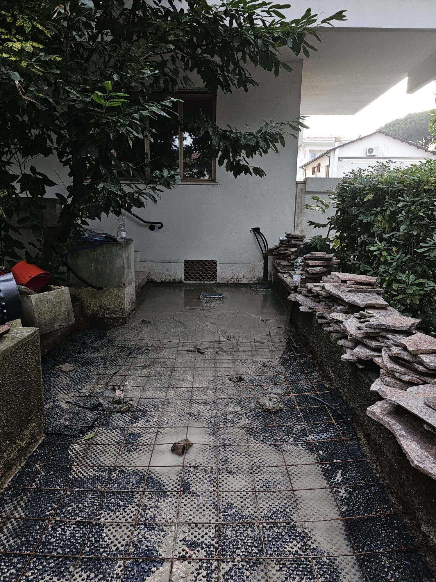 Un sentiero sporco che conduce a un edificio bianco con un albero sullo sfondo.