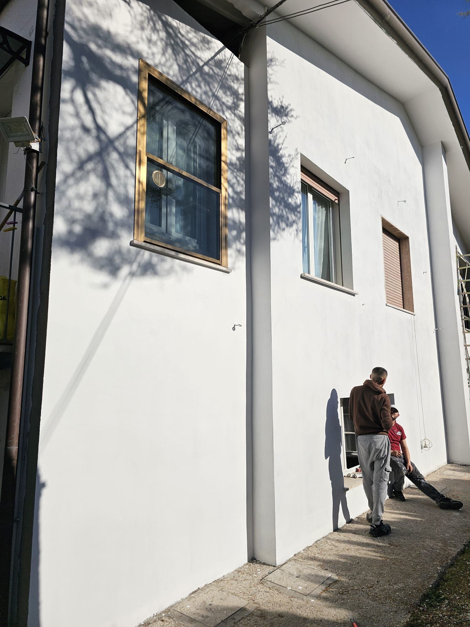 Un uomo è in piedi davanti a un edificio bianco.