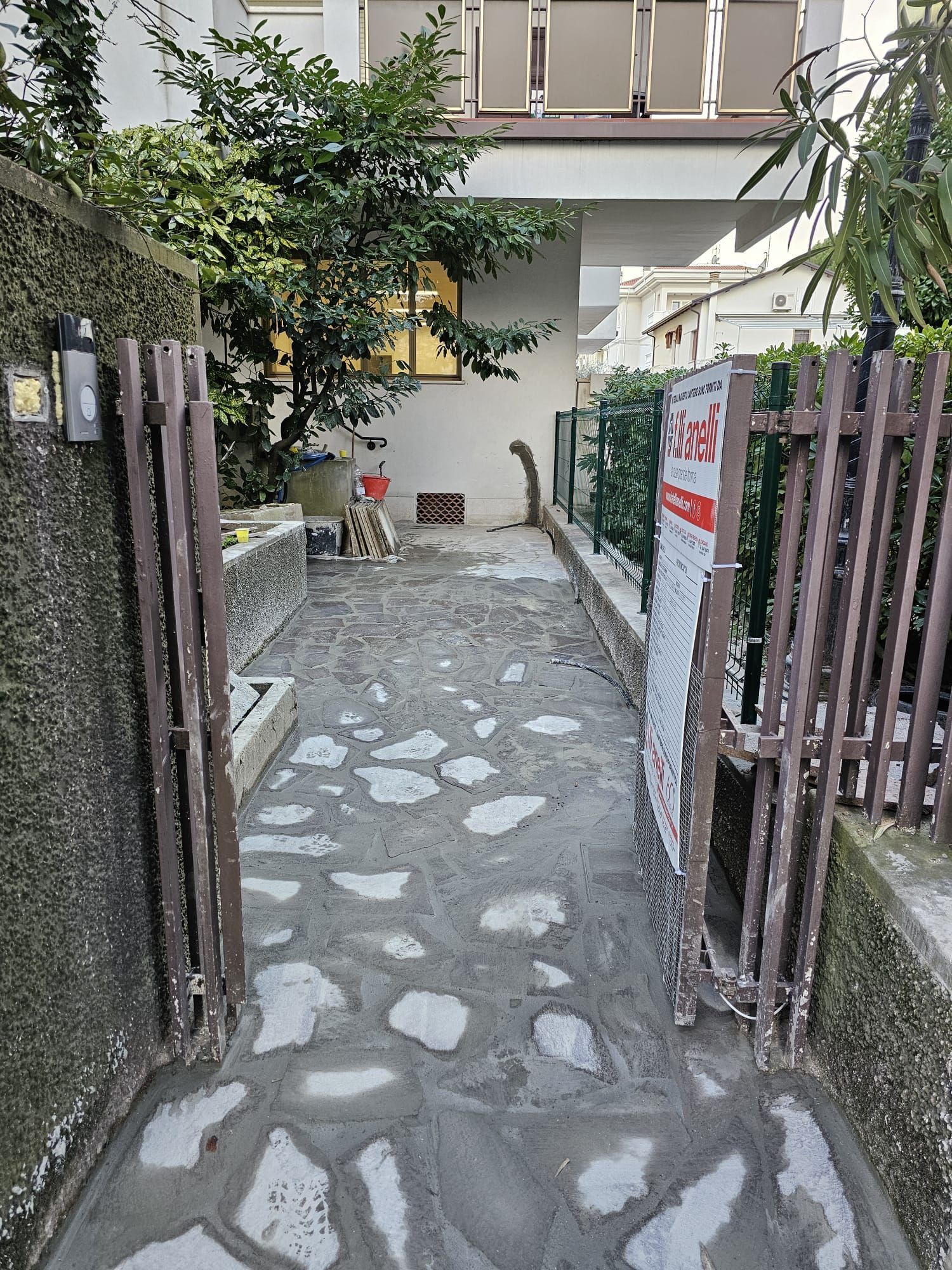 Un sentiero in pietra che conduce a una casa con un cancello aperto.