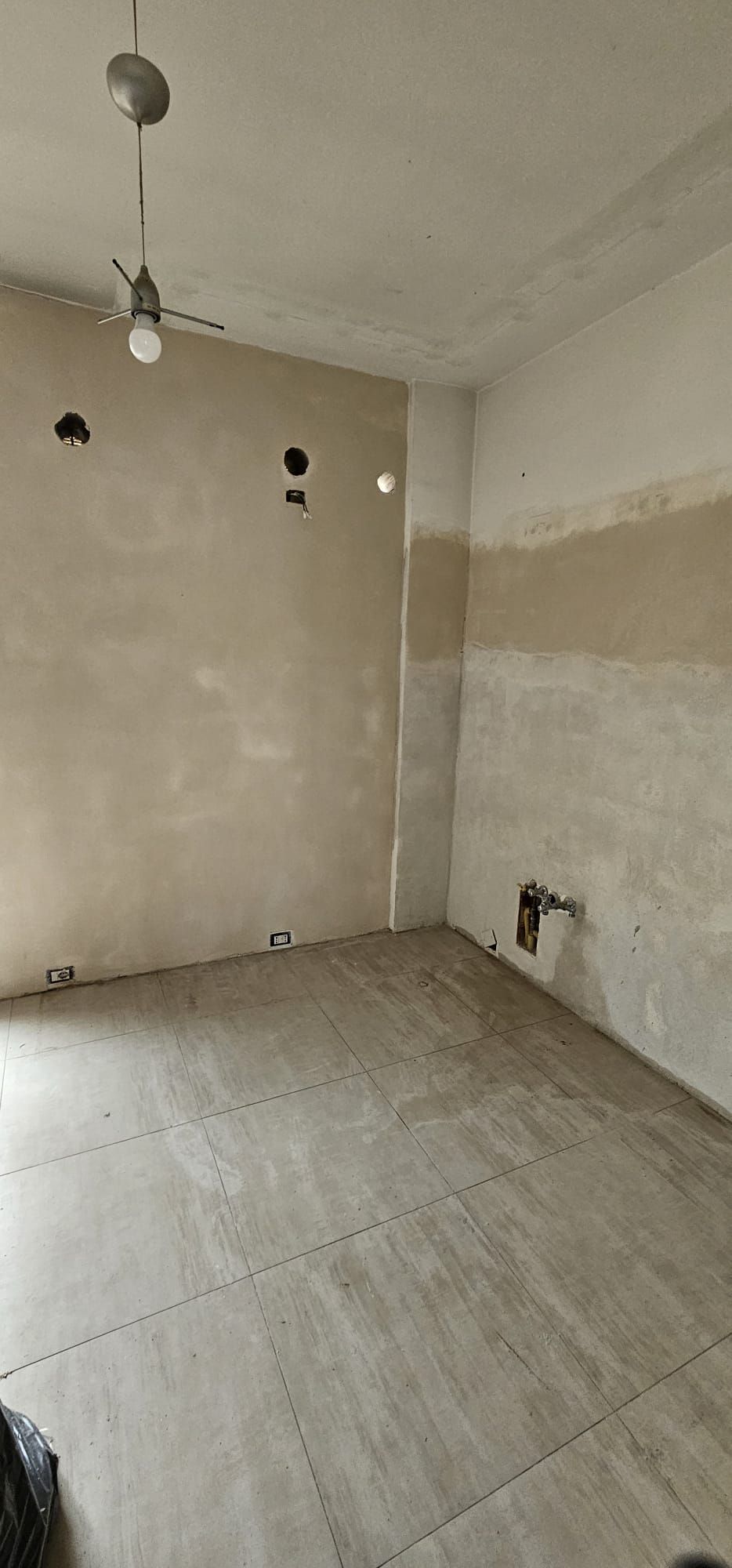 Una stanza vuota con un ventilatore a soffitto appeso al soffitto.