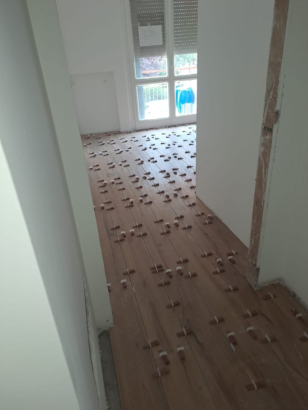 Un corridoio con un pavimento in legno e molte piastrelle.