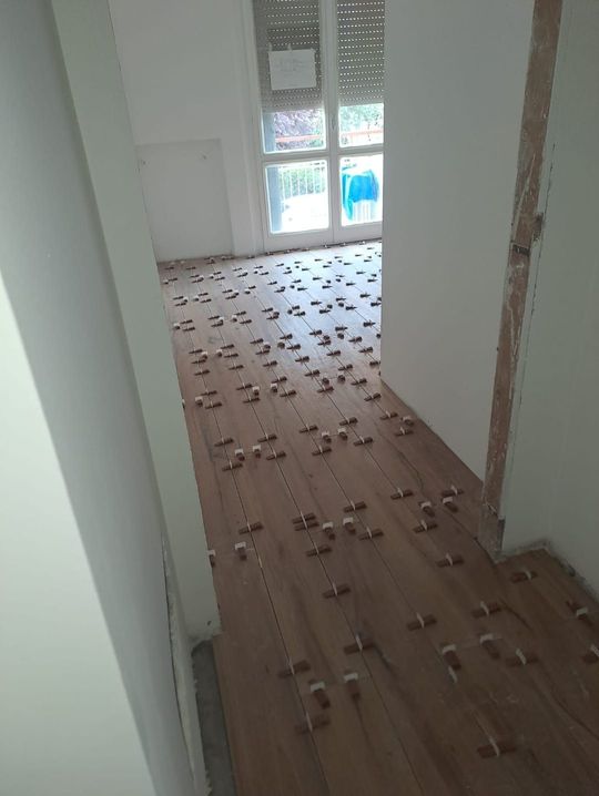 Un corridoio con un pavimento in legno e molte piastrelle.