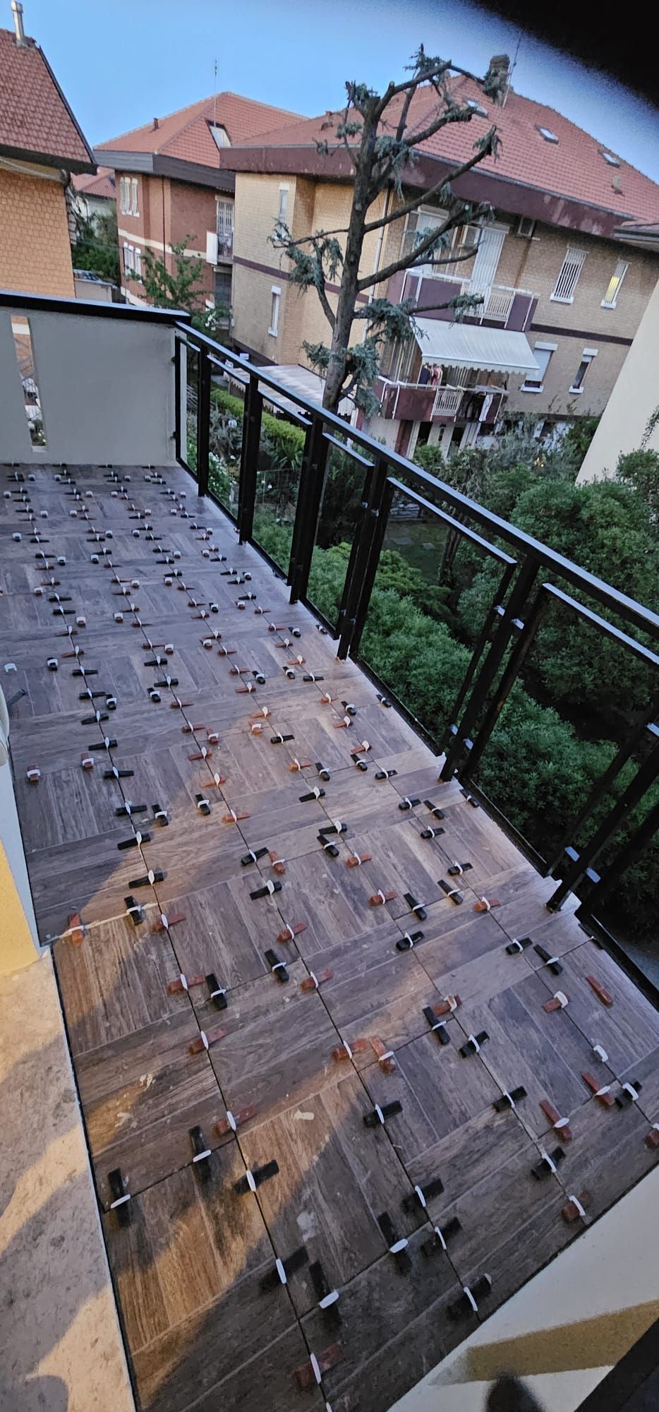 Un balcone con tante piastrelle e una ringhiera.