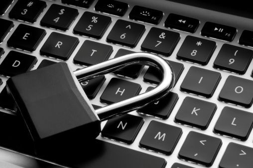 A padlock is sitting on top of a laptop keyboard.